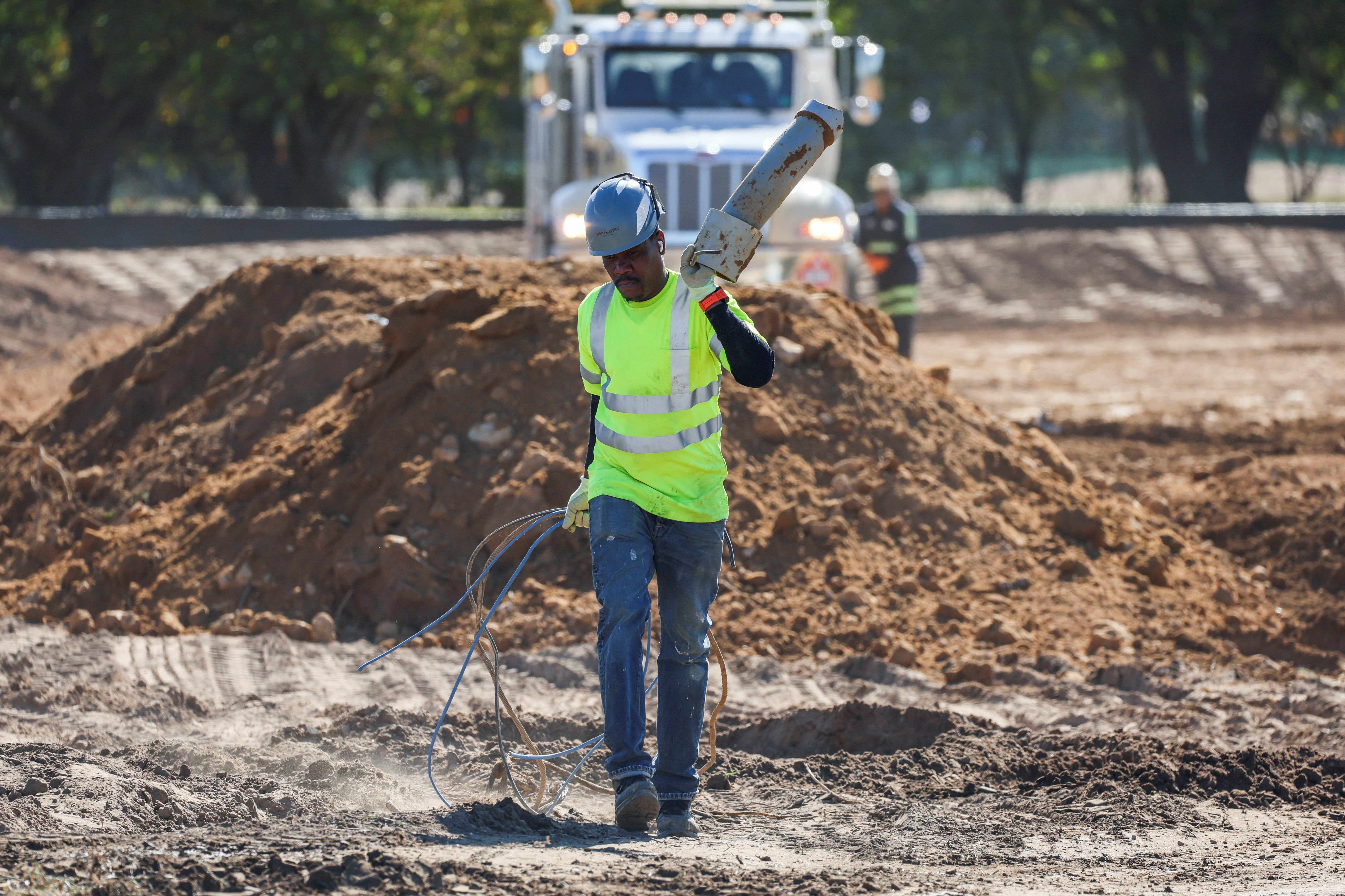 A construction worker walks through a makeshift dumpsite at the East Potomac Golf Course in Washington, D.C. A report from last month reveals President Donald Trump could be considering an idea to rebrand the golf course