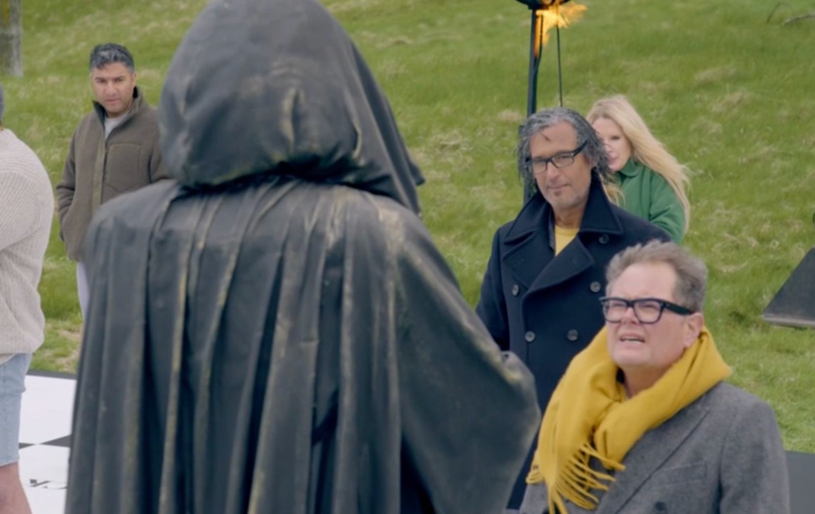 Alan Carr encara uma figura imponente do Traidor durante o