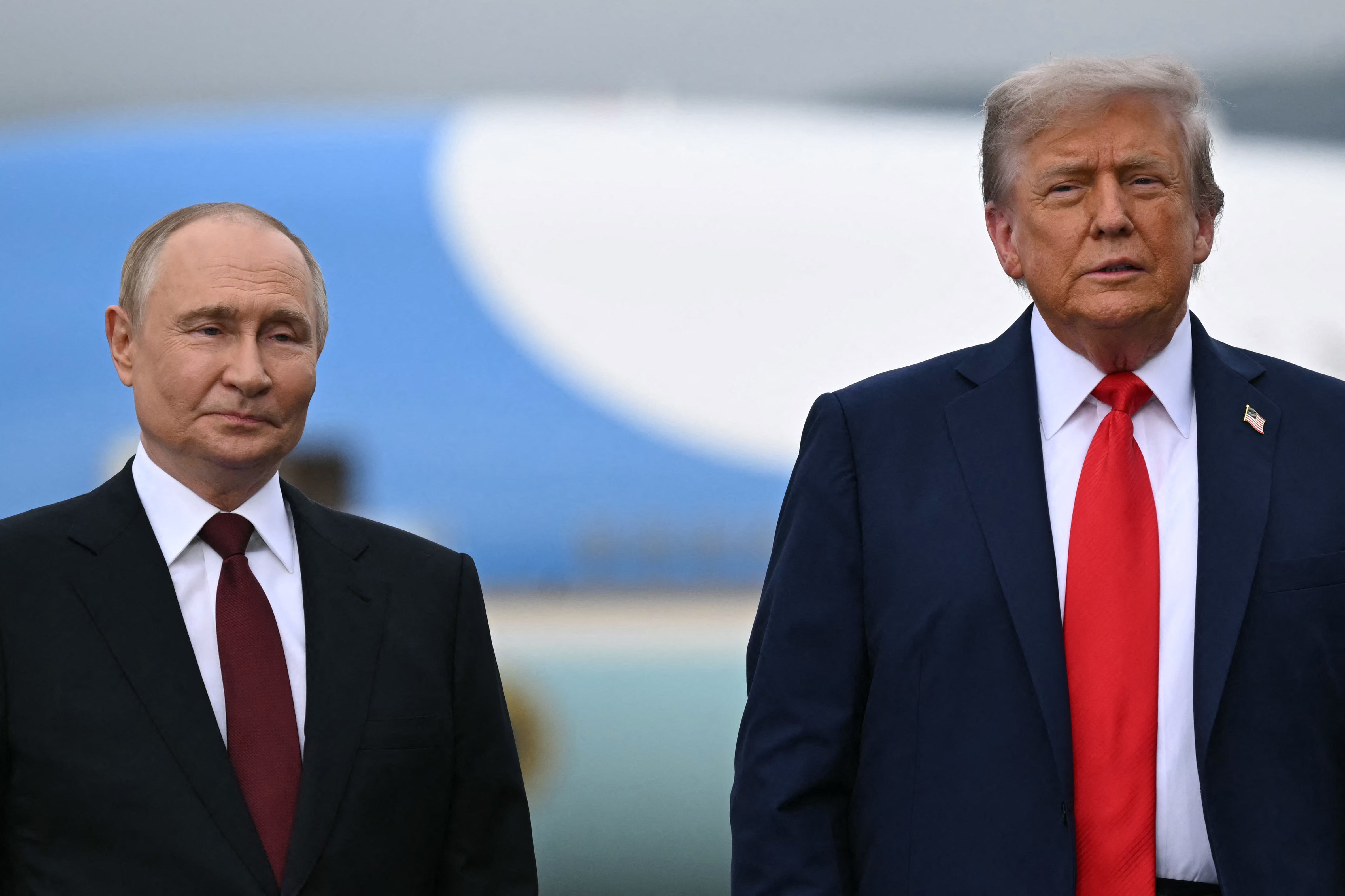 US President Donald Trump (R) and Russian President Vladimir Putin pose on a podium on the tarmac after arrival at Joint Base Elmendorf-Richardson in Anchorage, Alaska, on August 15, 2025. Putin is in Alaska at the invitation of Trump in his first visit to a Western country since he ordered the 2022 invasion of Ukraine that has killed tens of thousands of people