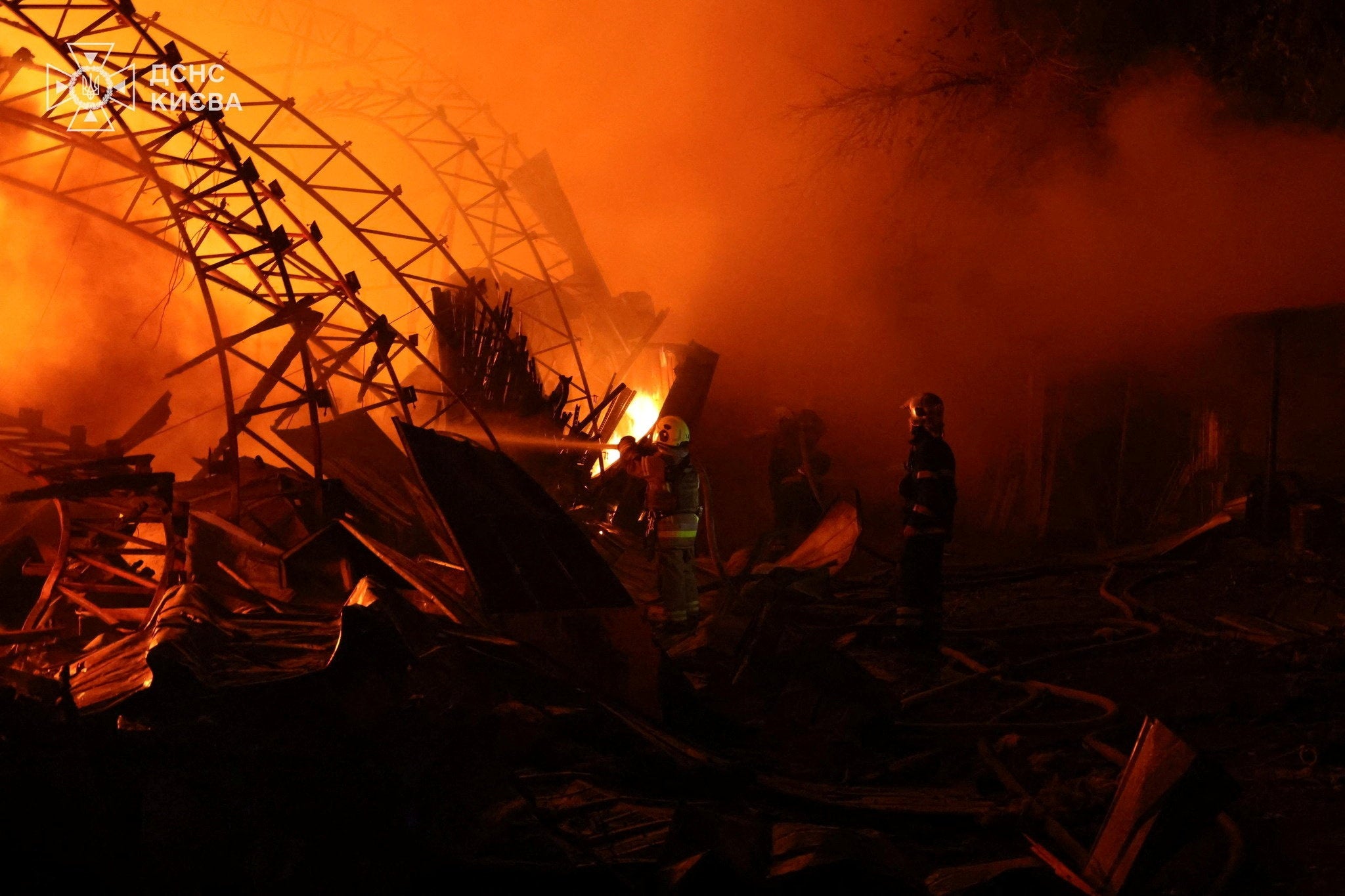 Firefighters work to put out a fire caused by Russian drone strike in Kyiv