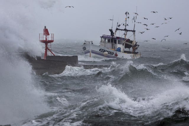 <p>A fishing boat arrives at the port of Plobannalec-Lesconil, in western France, on Wednesday as huge waves and strong winds hit the area</p>