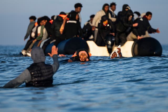 <p>Migrants board a dinghy near Gravelines in northern France last month</p>