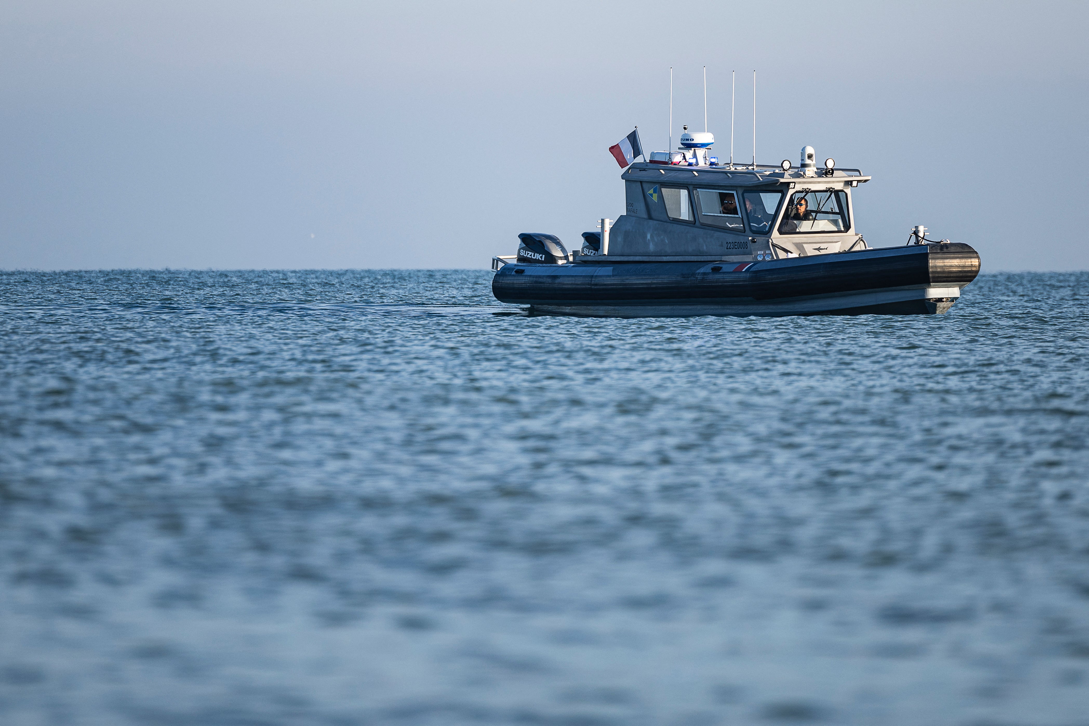A French Maritime Gendarmerie vessel sails near smugglers’ boats with migrants onboard as they attempt to cross the English Channel