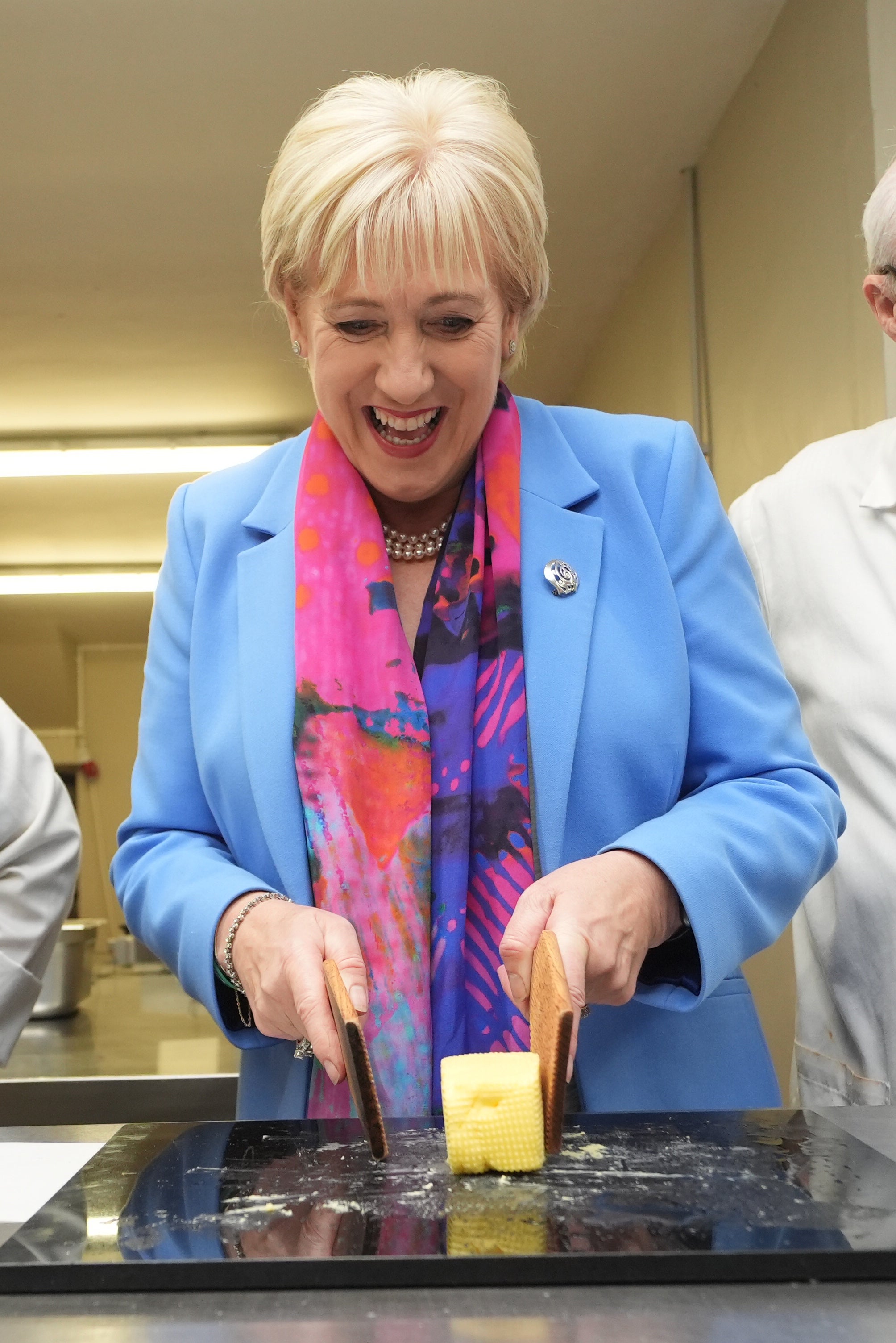Heather Humphreys trying butter patting while campaigning at Dunhill Eco Park in Waterford (Brian Lawless/PA)