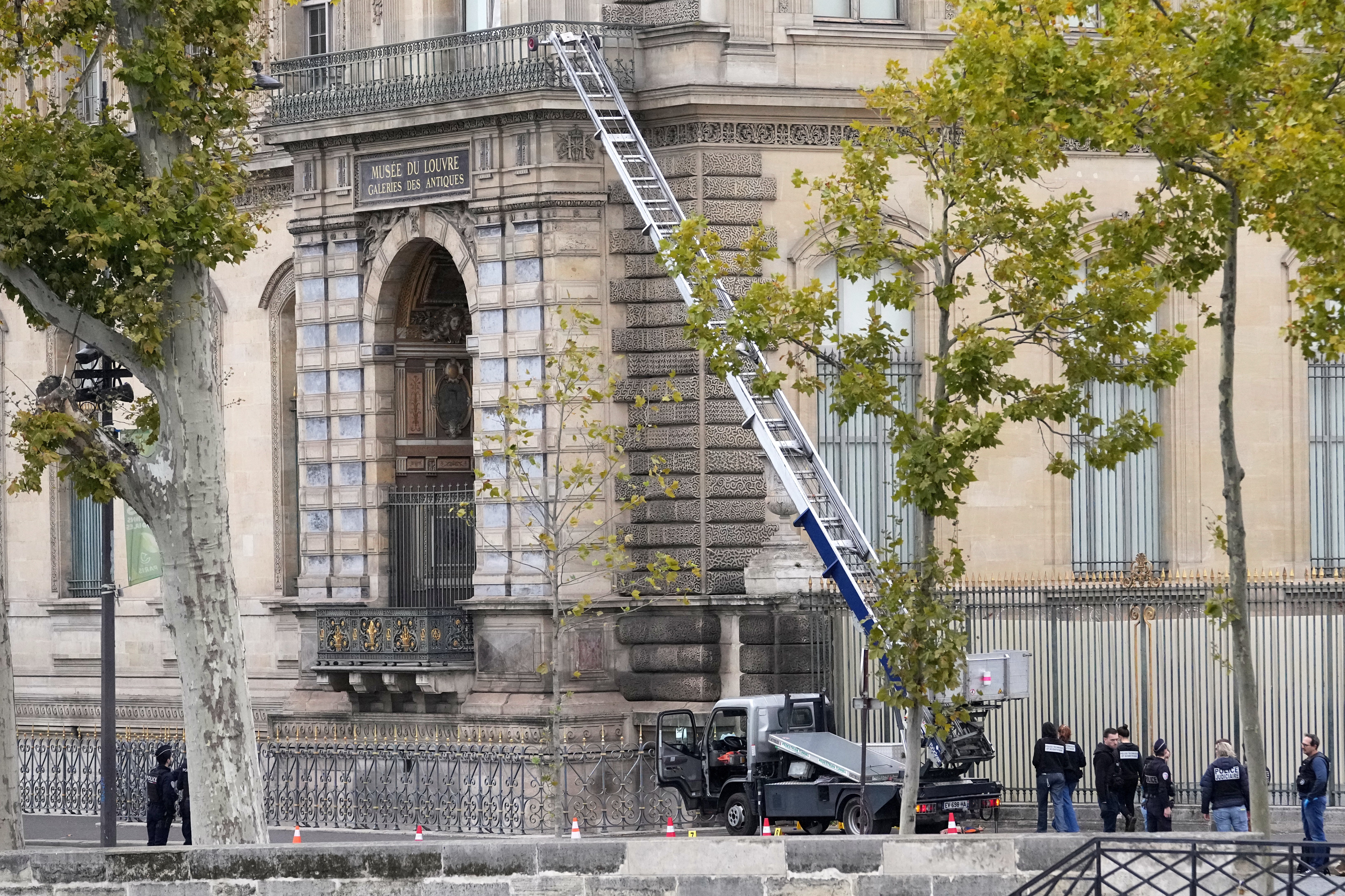 Police officers work by a basket lift used by thieves at the Louvre museum in Paris