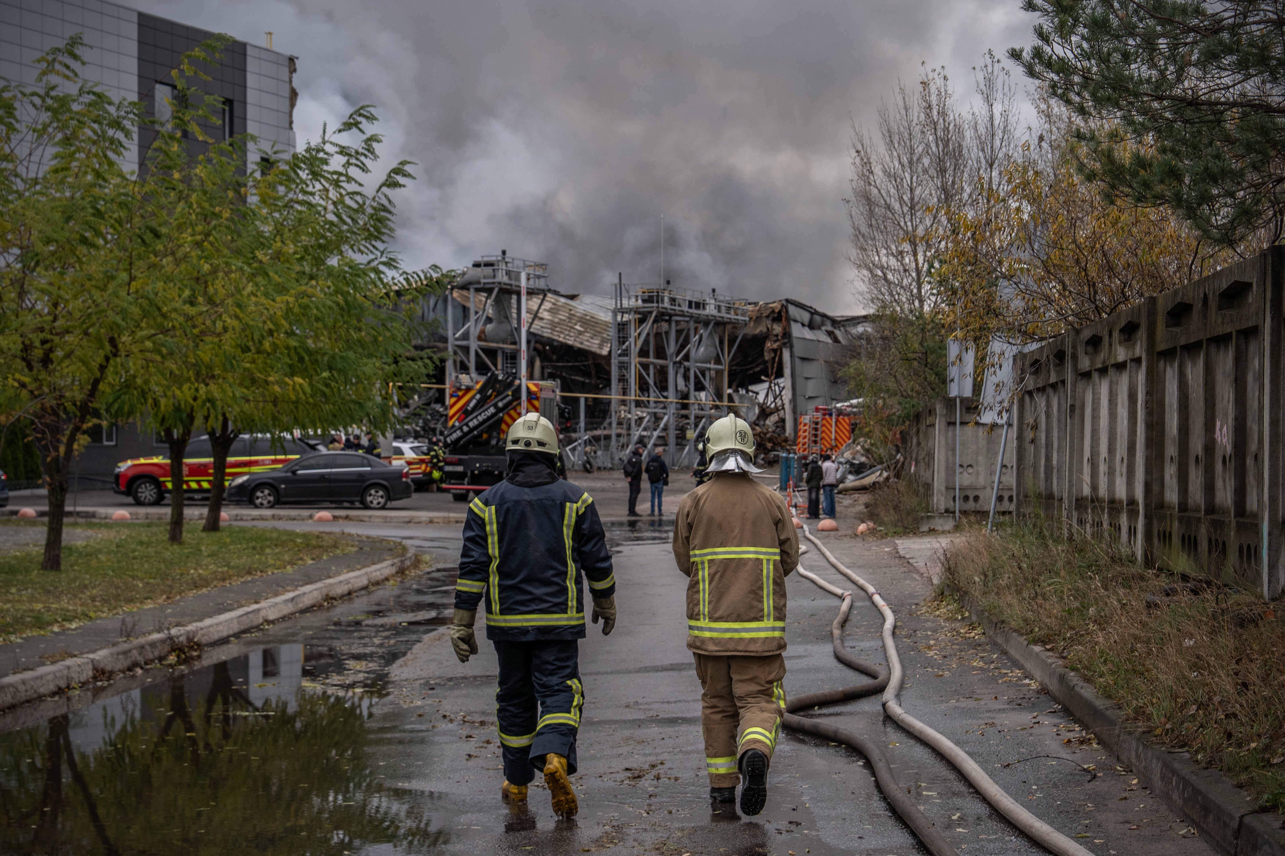 Firefighters walk towards a warehouse that caught fire following a Russian attack, Saturday, Oct. 25, 2025, in Kyiv, Ukraine. (AP Photo/Julia Demaree Nikhinson)