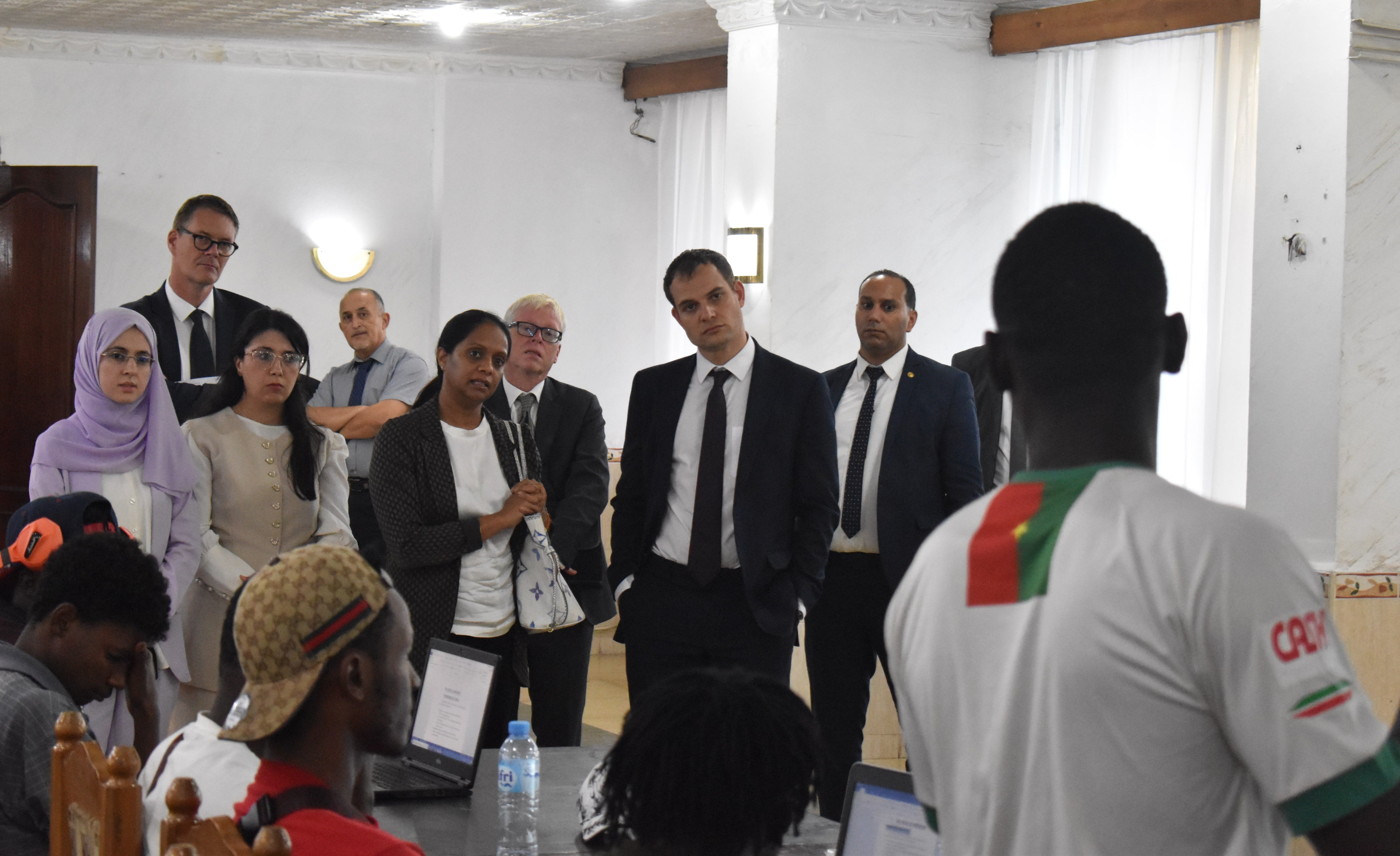 Hamish Falconer (centre) visits a migrant processing centre in Algeria