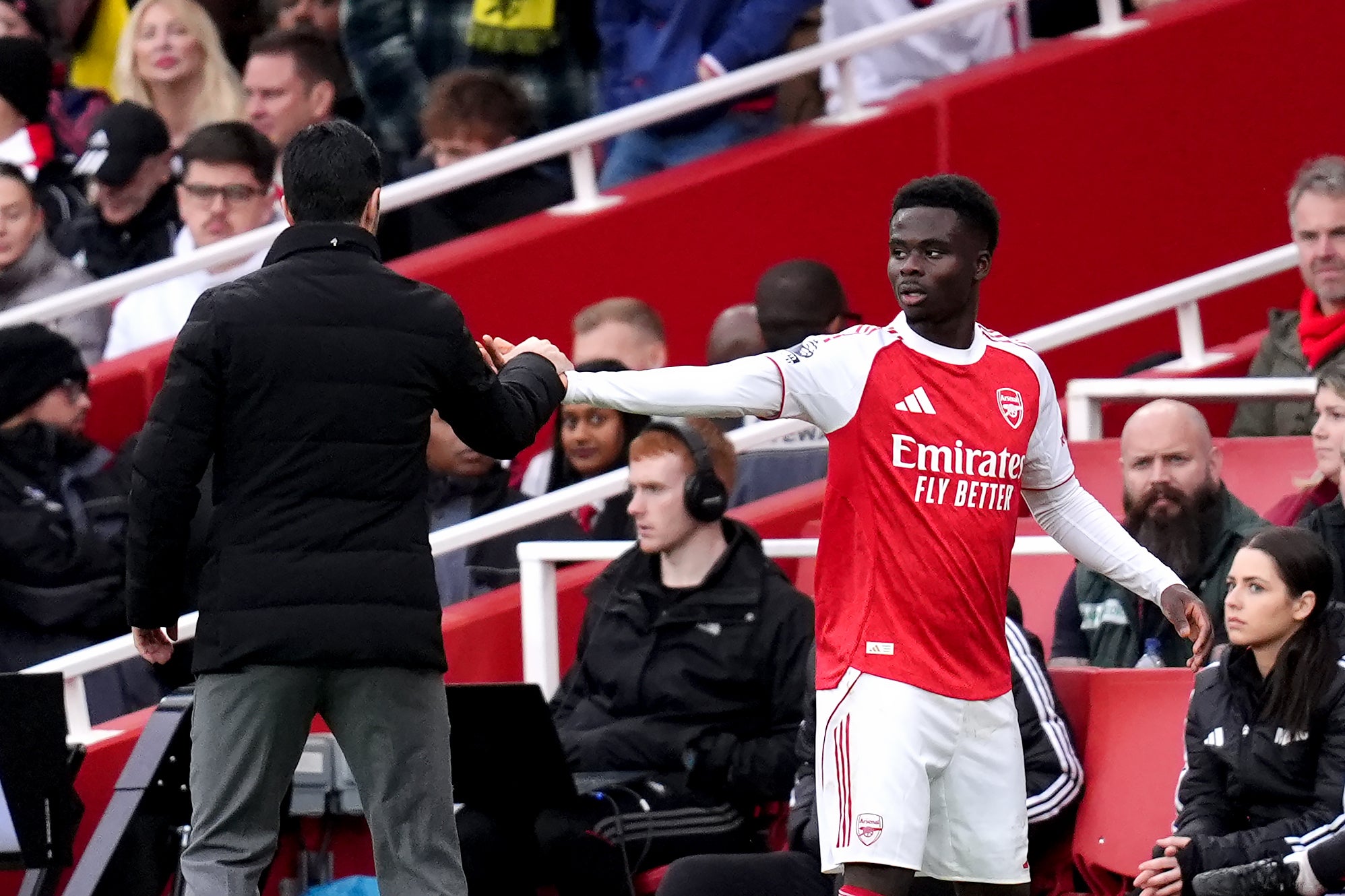 Arsenal’s Bukayo Saka (right) greets manager Mikel Arteta (John Walton/PA)