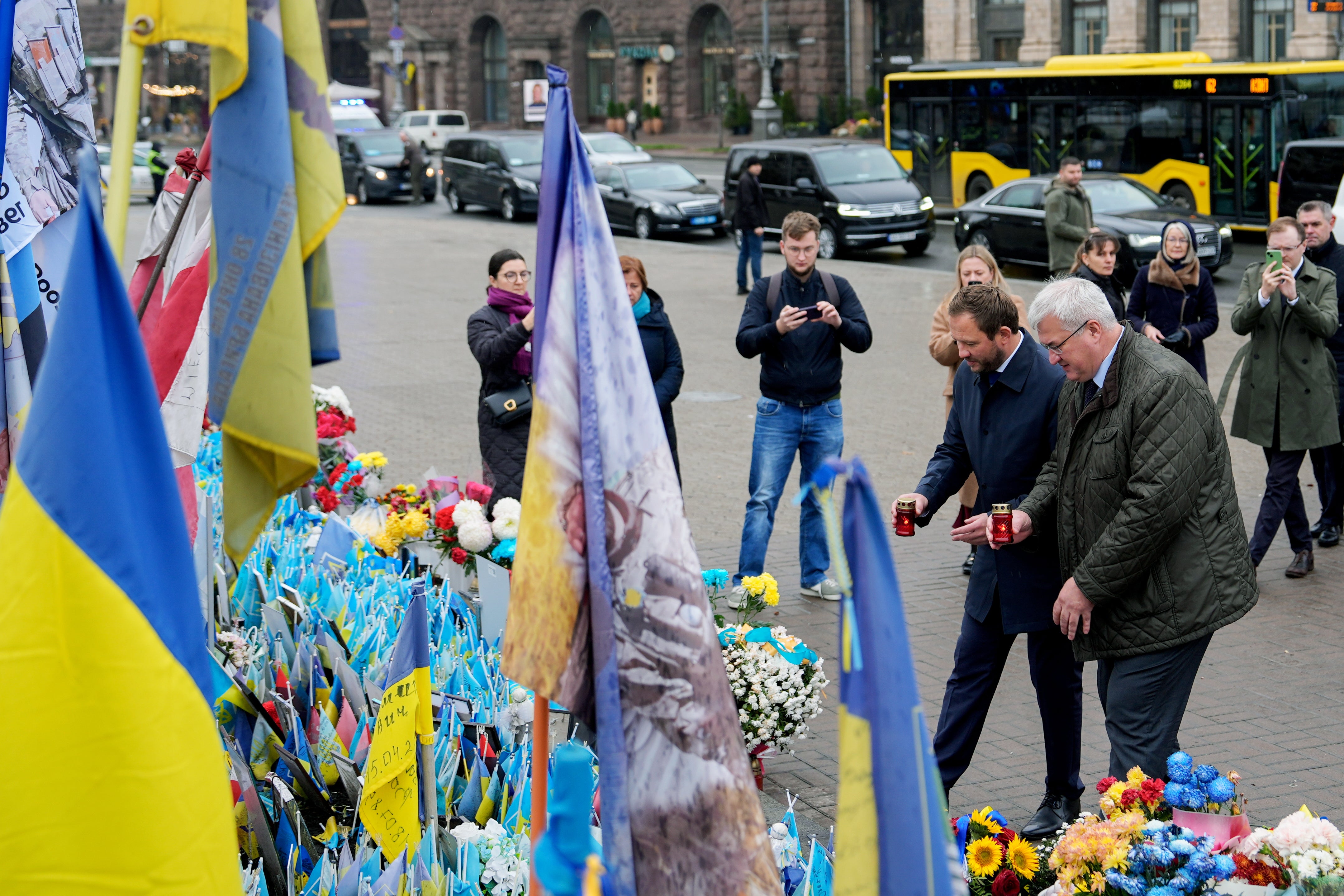 Ukraine's Foreign Minister Andrii Sybiha and Estonia's Minister of Foreign Affairs Margus Tsahkna place candles at a memorial for fallen Ukrainian soldiers in Independence Square, Monday, Oct. 27, 2025, in Kyiv, Ukraine. (AP Photo/Julia Demaree Nikhinson)