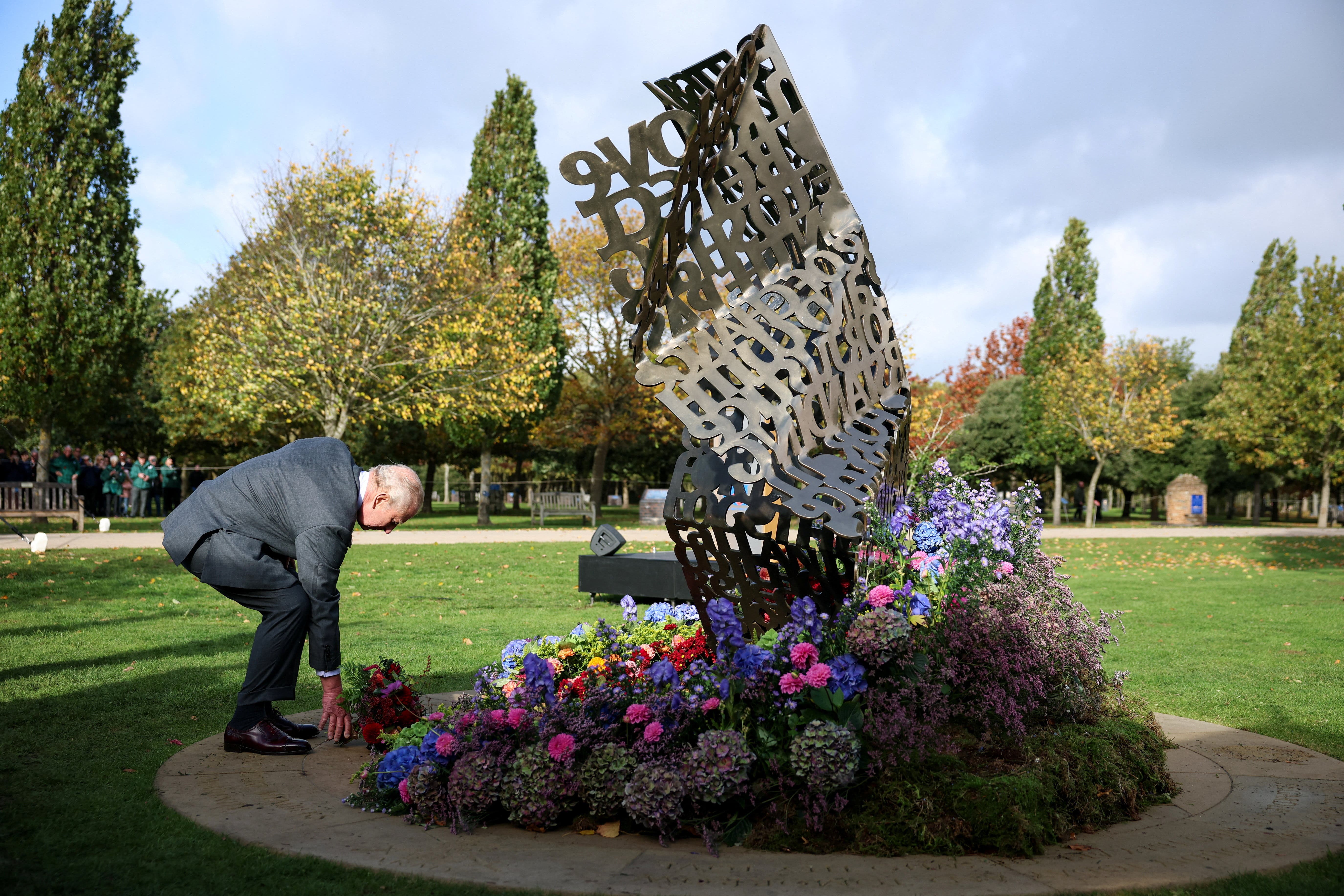 The King lays flowers during the dedication ceremony of the LGBT armed forces memorial (Phil Noble/PA)