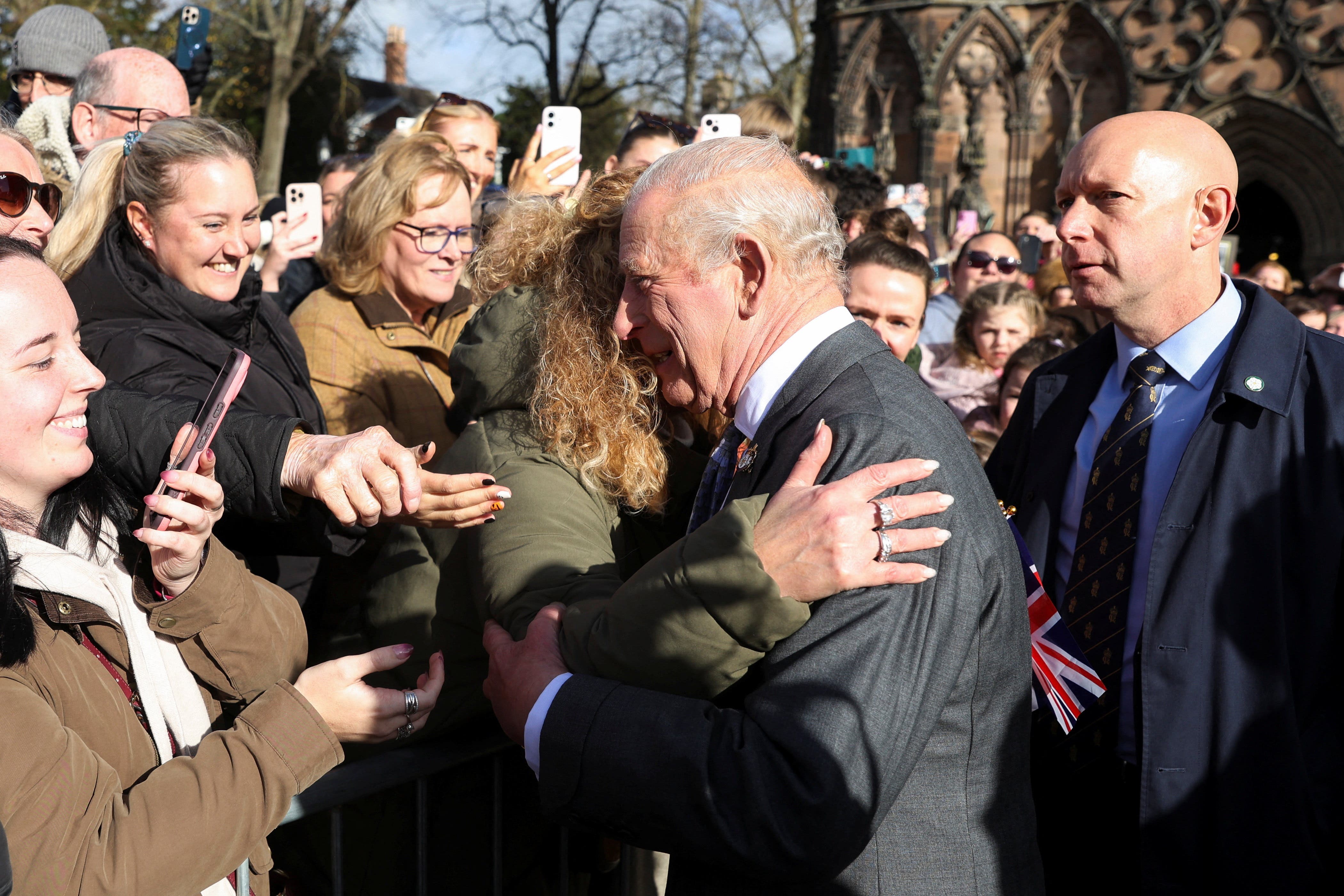 The King is embraced by a member of the public as he arrives at Lichfield Cathedral (Temilade Adelaja/PA)