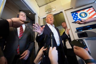 Donald Trump speaks to reporters onboard Air Force One