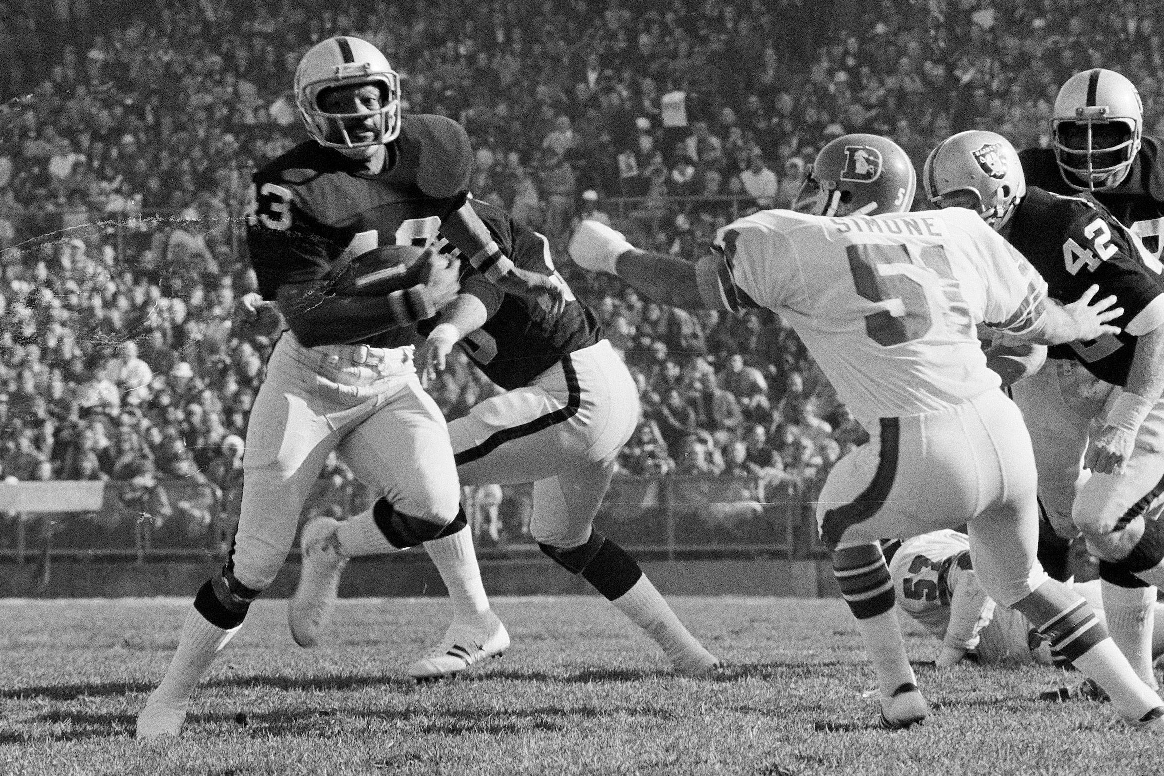 George Atkinson (43), of the Oakland Raiders, breaks inside Mike Simone (51) of the Denver Broncos as he returned a Broncos punt 32 yards, in Oakland, Calif., Dec. 16, 1973. (AP Photo, file)