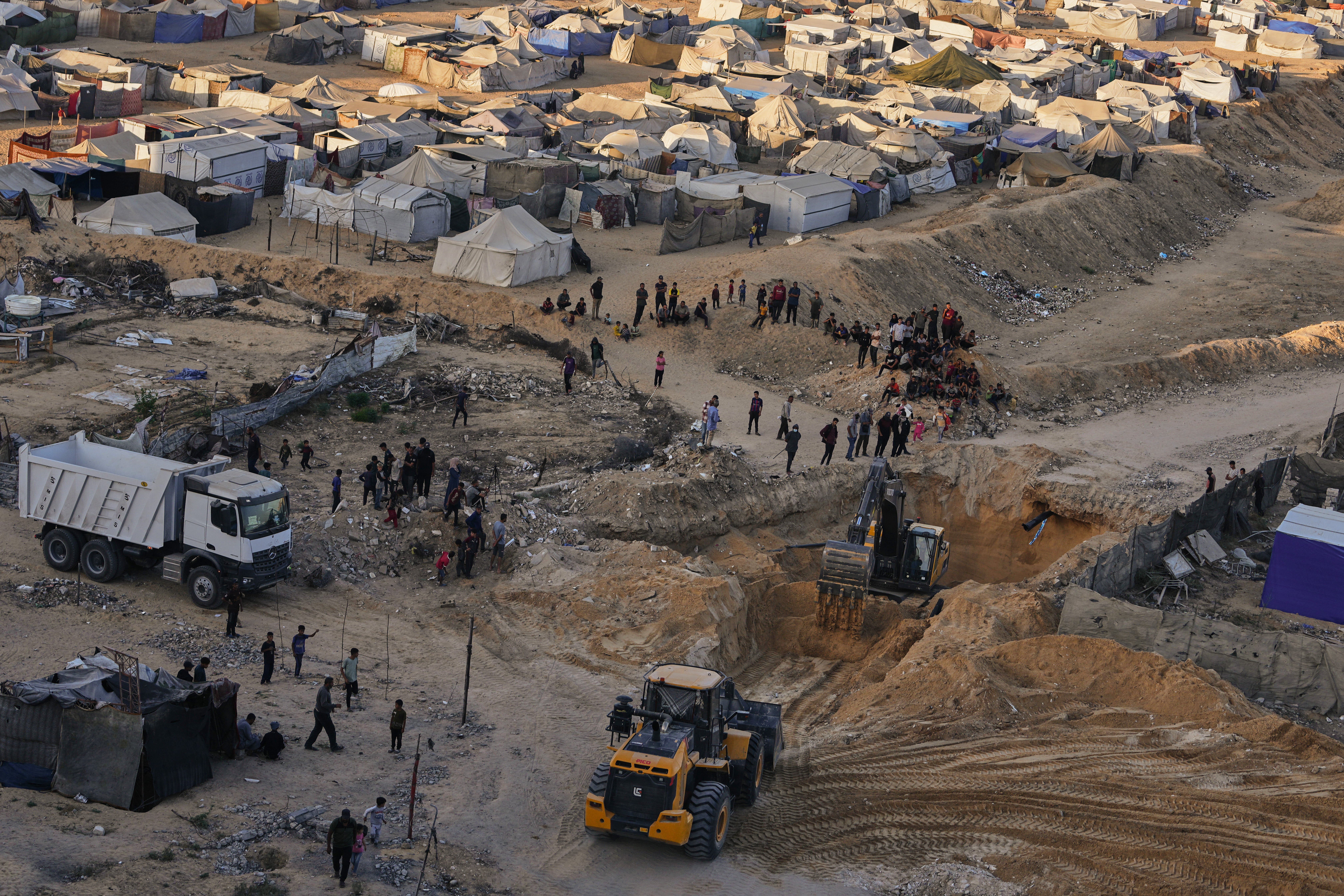 Palestinians work to recover the bodies of hostages in Gaza on Monday