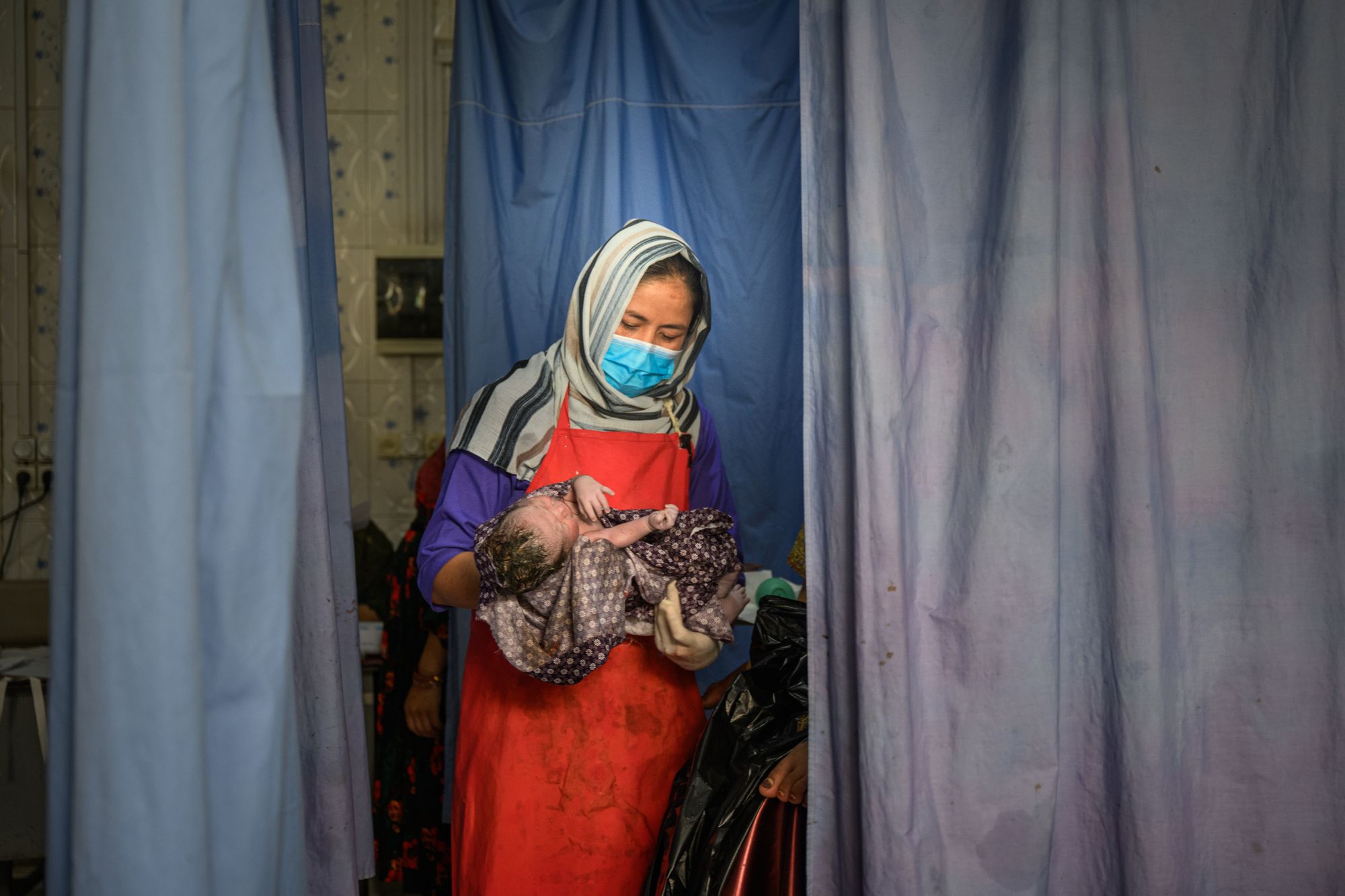 A midwife holds a newborn after a delivery at the provincial hospital's maternity unit in Ghazni