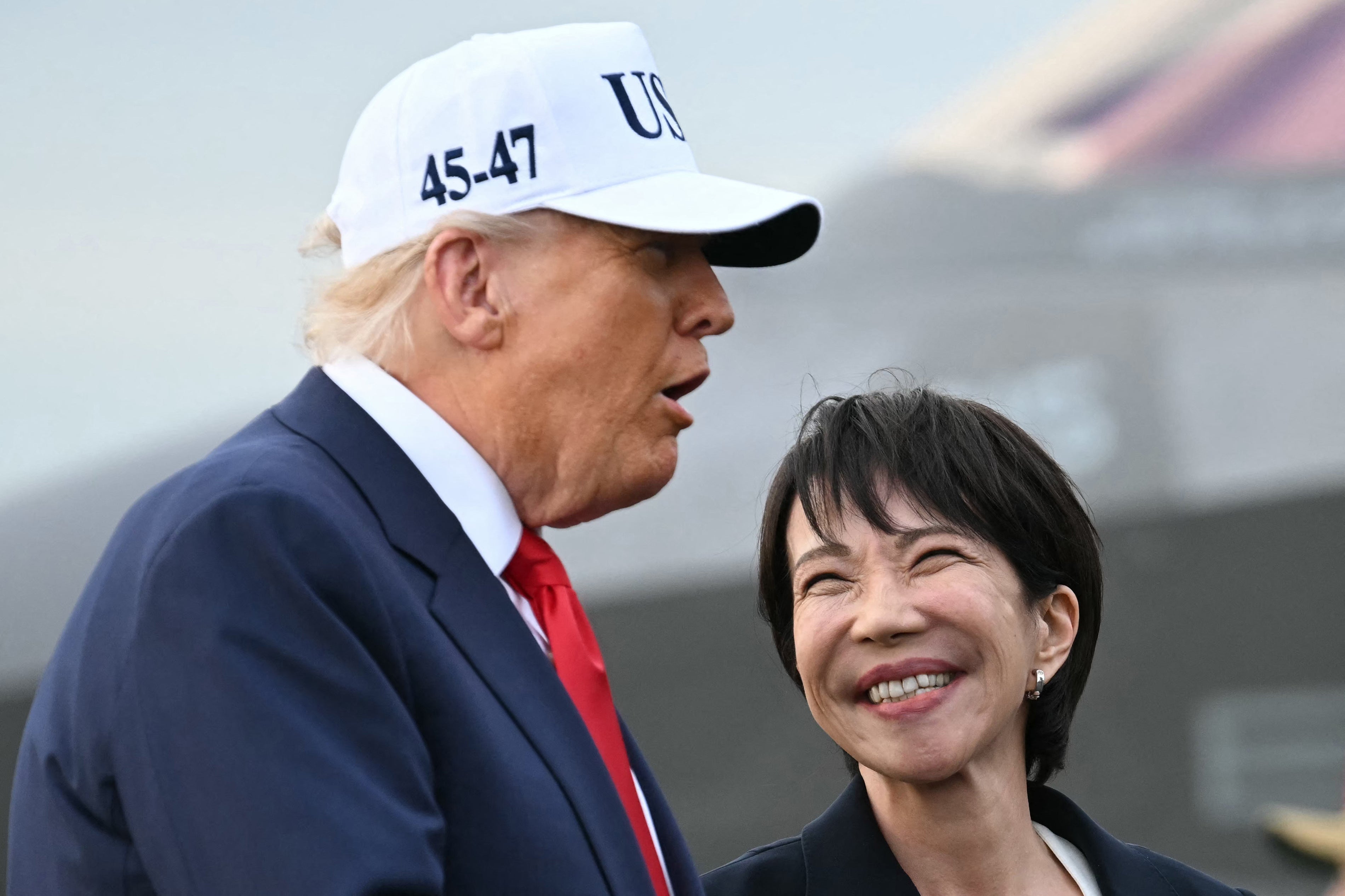 US President Donald Trump (L) and Japan's Prime Minister Sanae Takaichi arrive on board the US Navy's USS George Washington aircraft carrier at the US naval base in Yokosuk