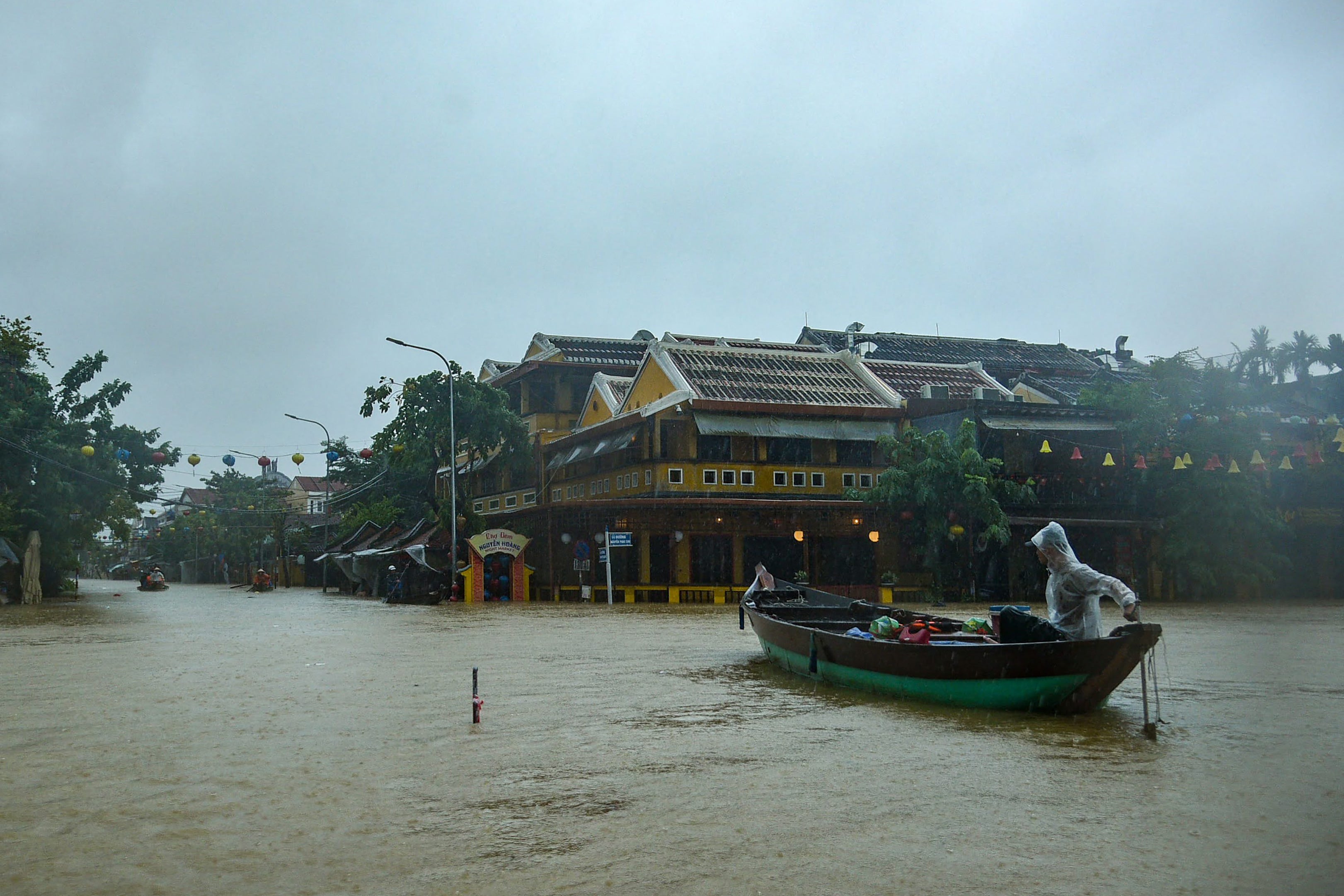 People navigate a flooded road on a boat following heavy rains in Hoi An in central Vietnam.