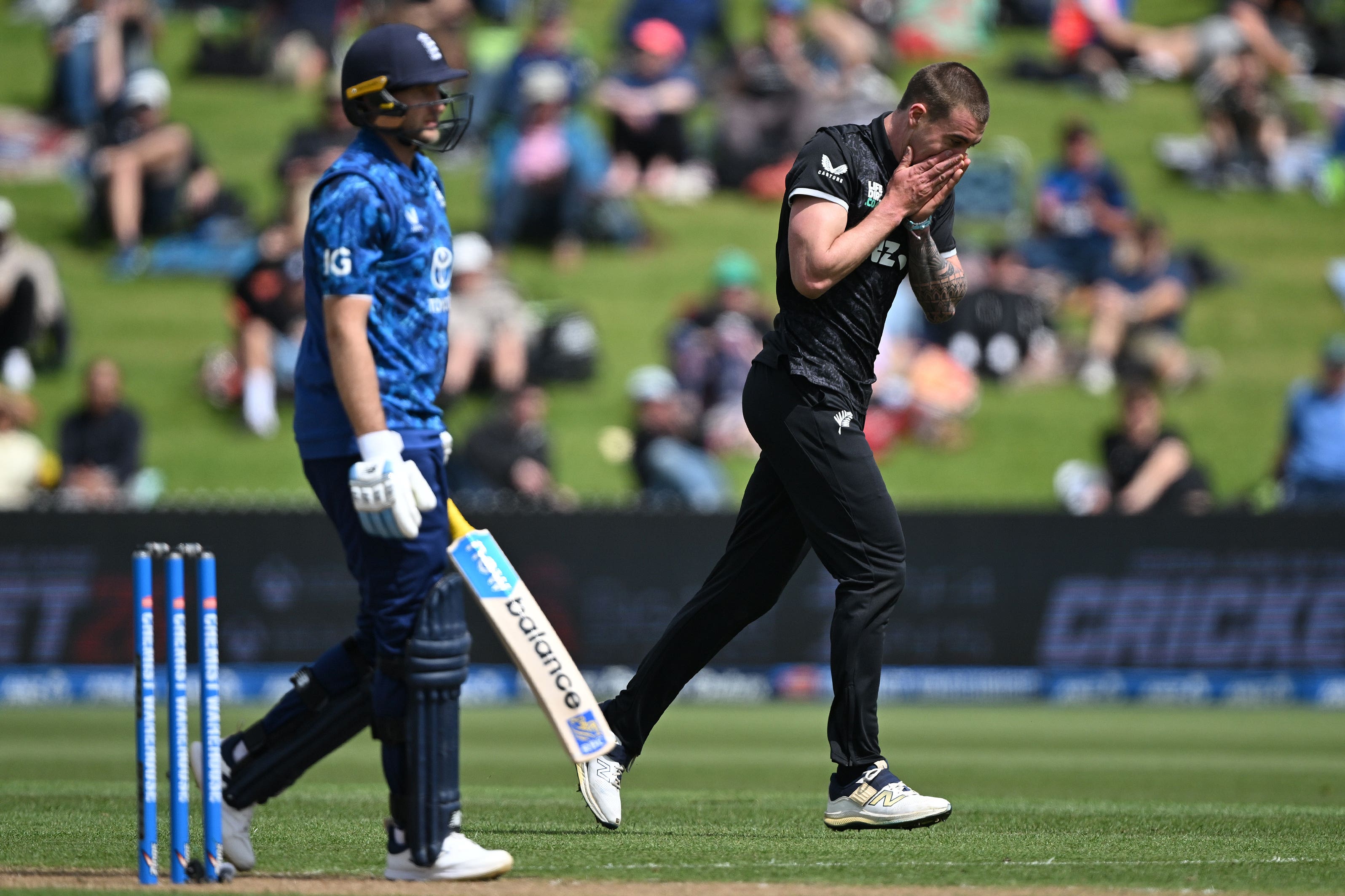 New Zealand bowler Blair Tickner, right, reacts after taking the wicket of England’s Joe Root, left (Andrew Cornaga/AP)