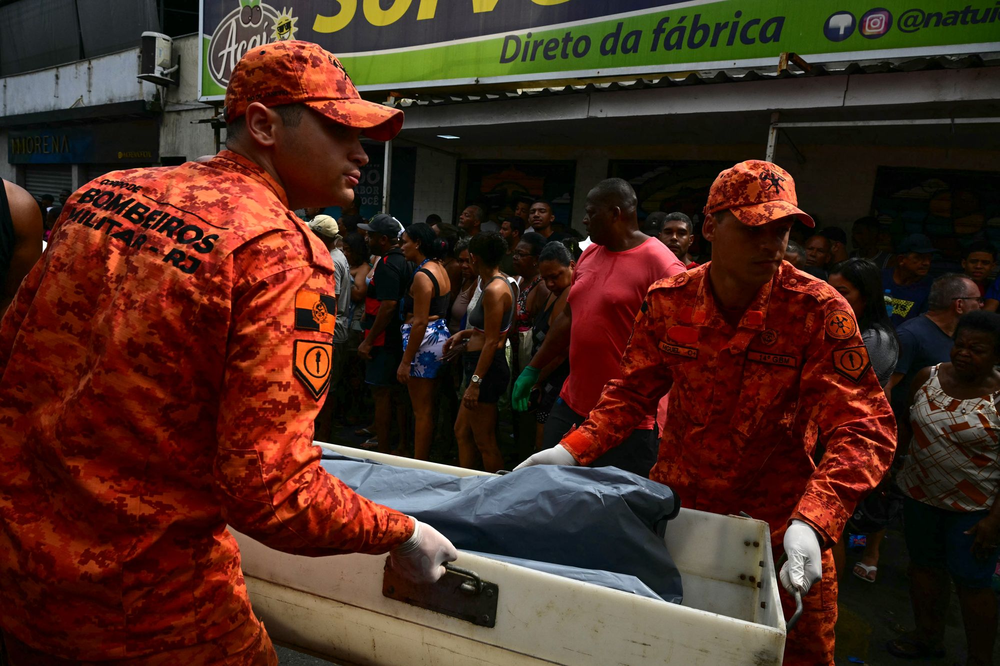 Firefighters carry a body on Sao Lucas Square of the Vila Cruzeiro favela at the Penha complex in Rio de Janeiro, Brazil.