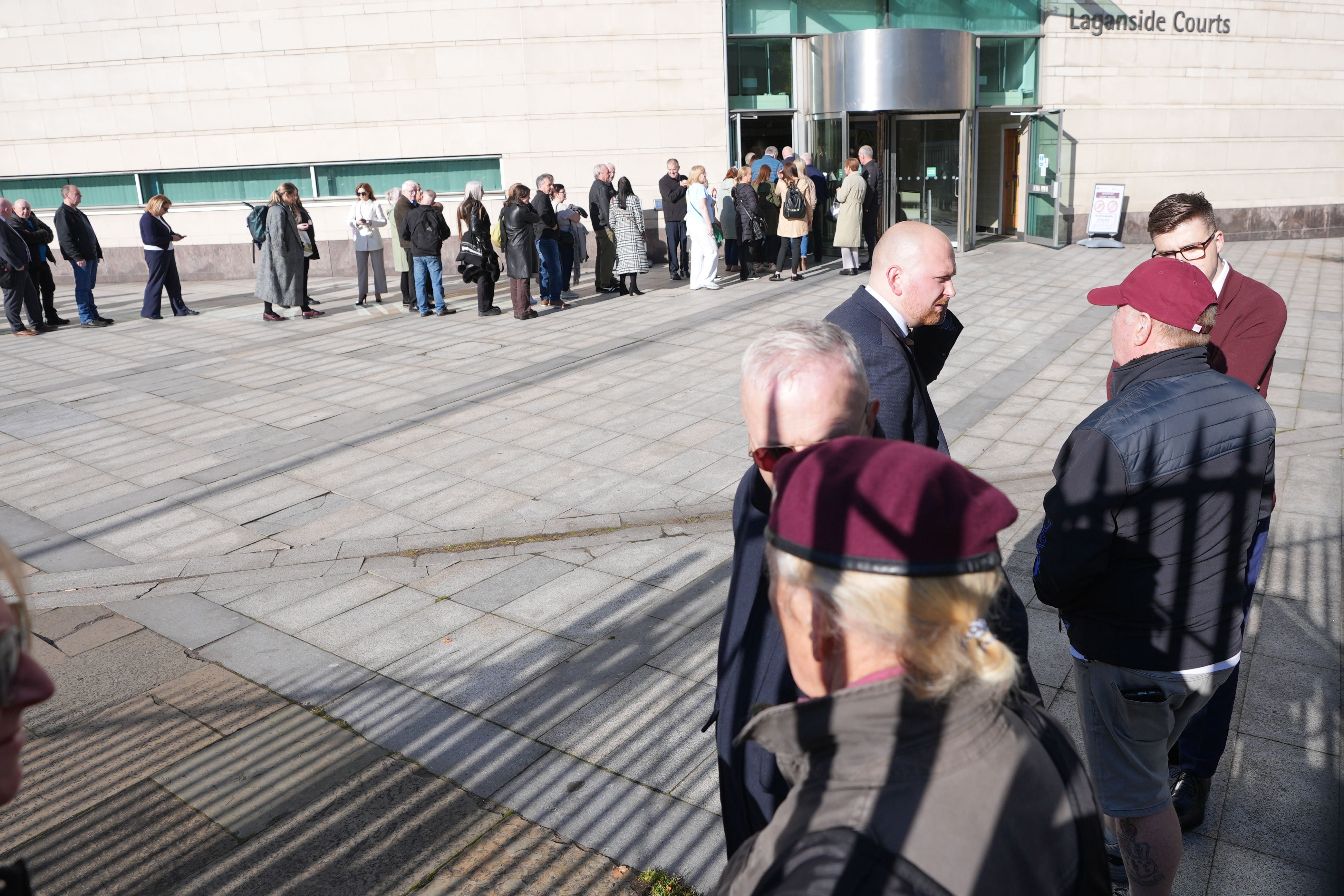 Supporters of Soldier F look on as relatives and supporters of those killed on Bloody Sunday queue to enter Belfast Crown Court (PA)