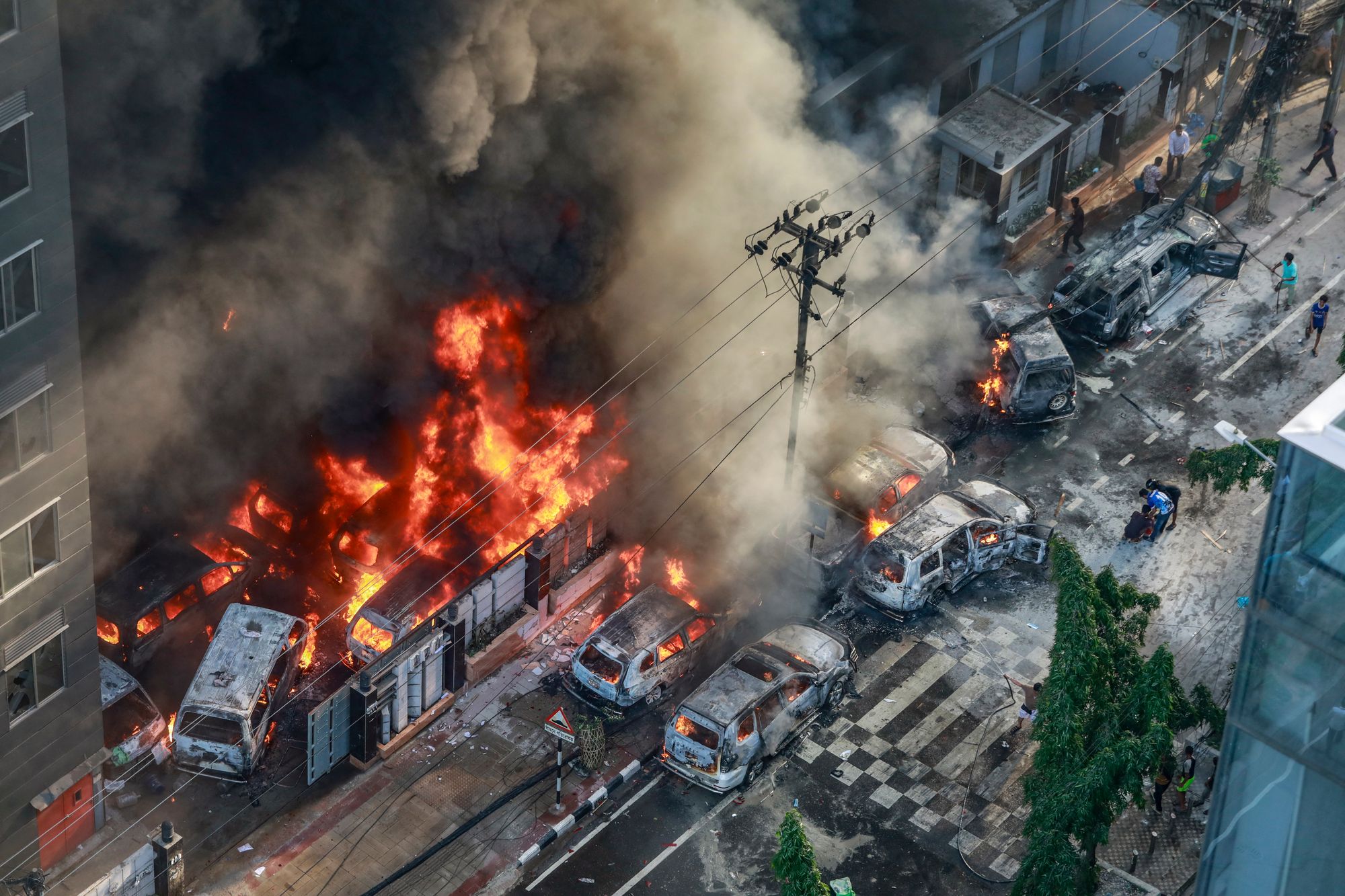 Smoke rises from the burning vehicles after protesters set them on fire near the Disaster Management Directorate office in July 2024
