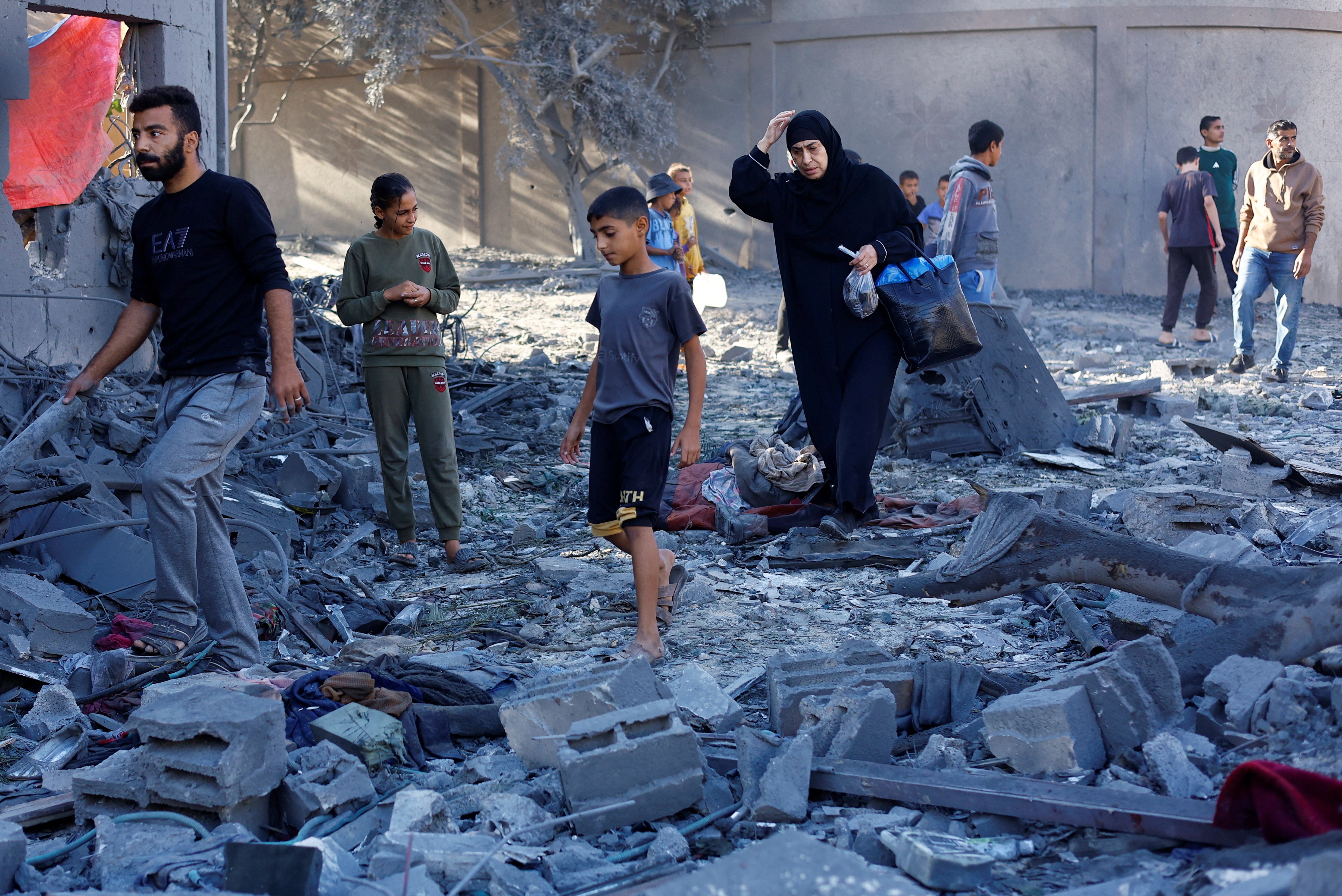<p>Palestinians at the aftermath of an Israeli strike on a house in Nuseirat on Wednesday</p>