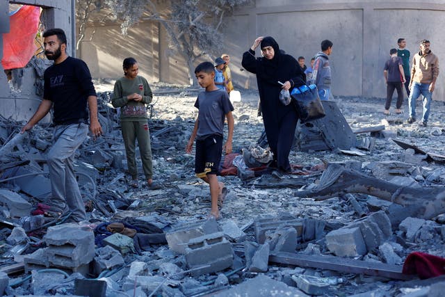 <p>Palestinians at the aftermath of an Israeli strike on a house in Nuseirat on Wednesday</p>