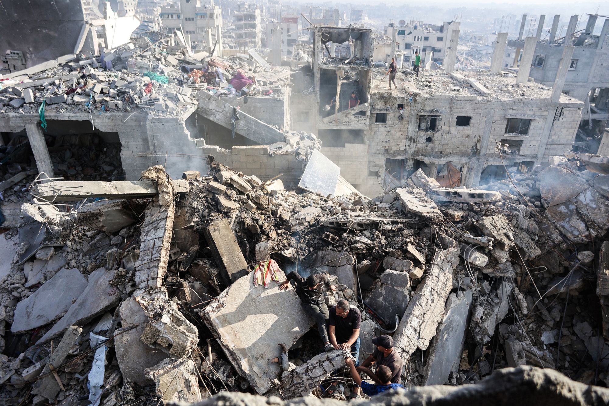 Palestinians try to recover a body from the rubble of a house destroyed in an overnight Israeli strike, in Gaza City, on October 29, 2025
