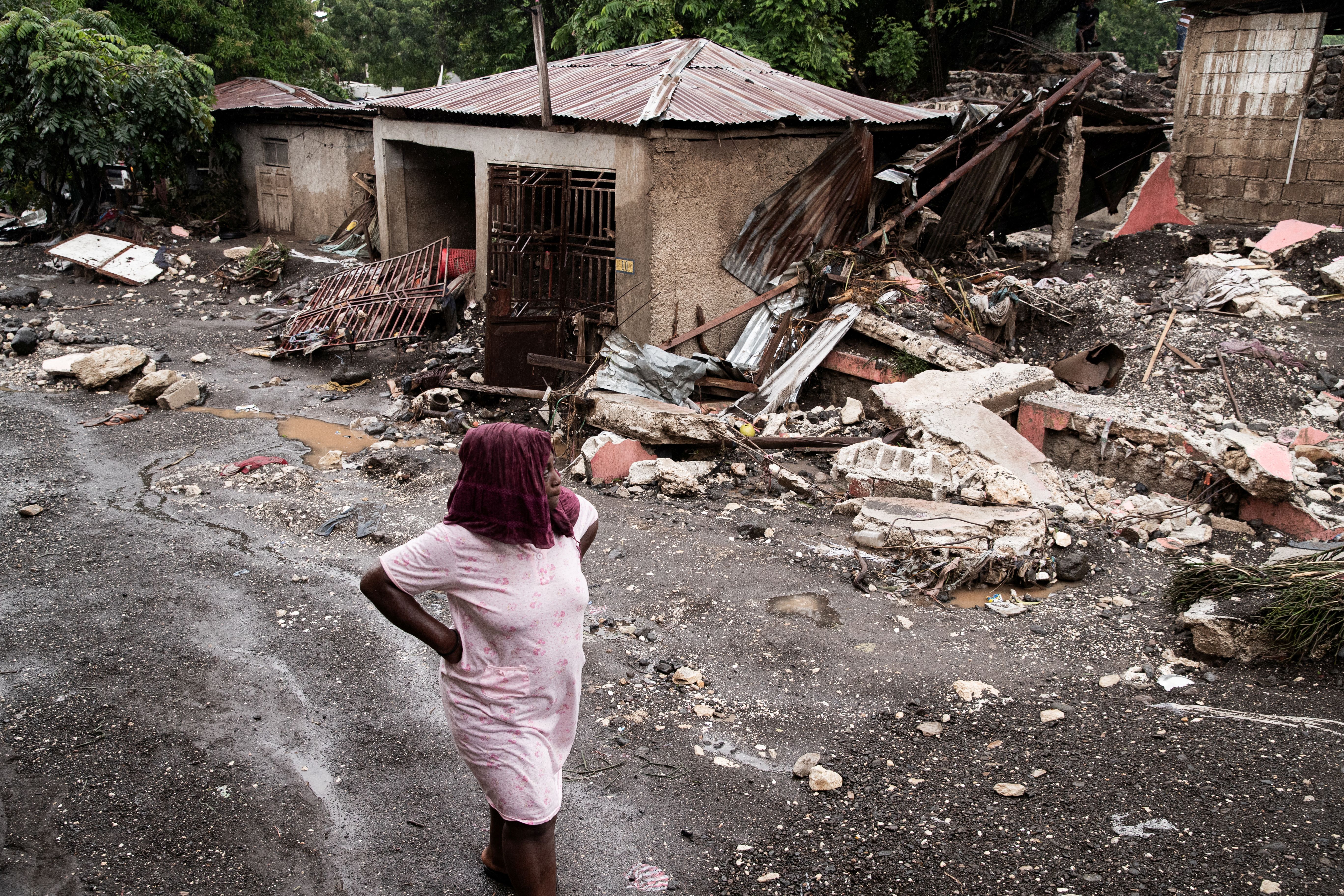 A woman walks past her house that was destroyed by Hurricane Melissa in Petit-Goave, Haiti