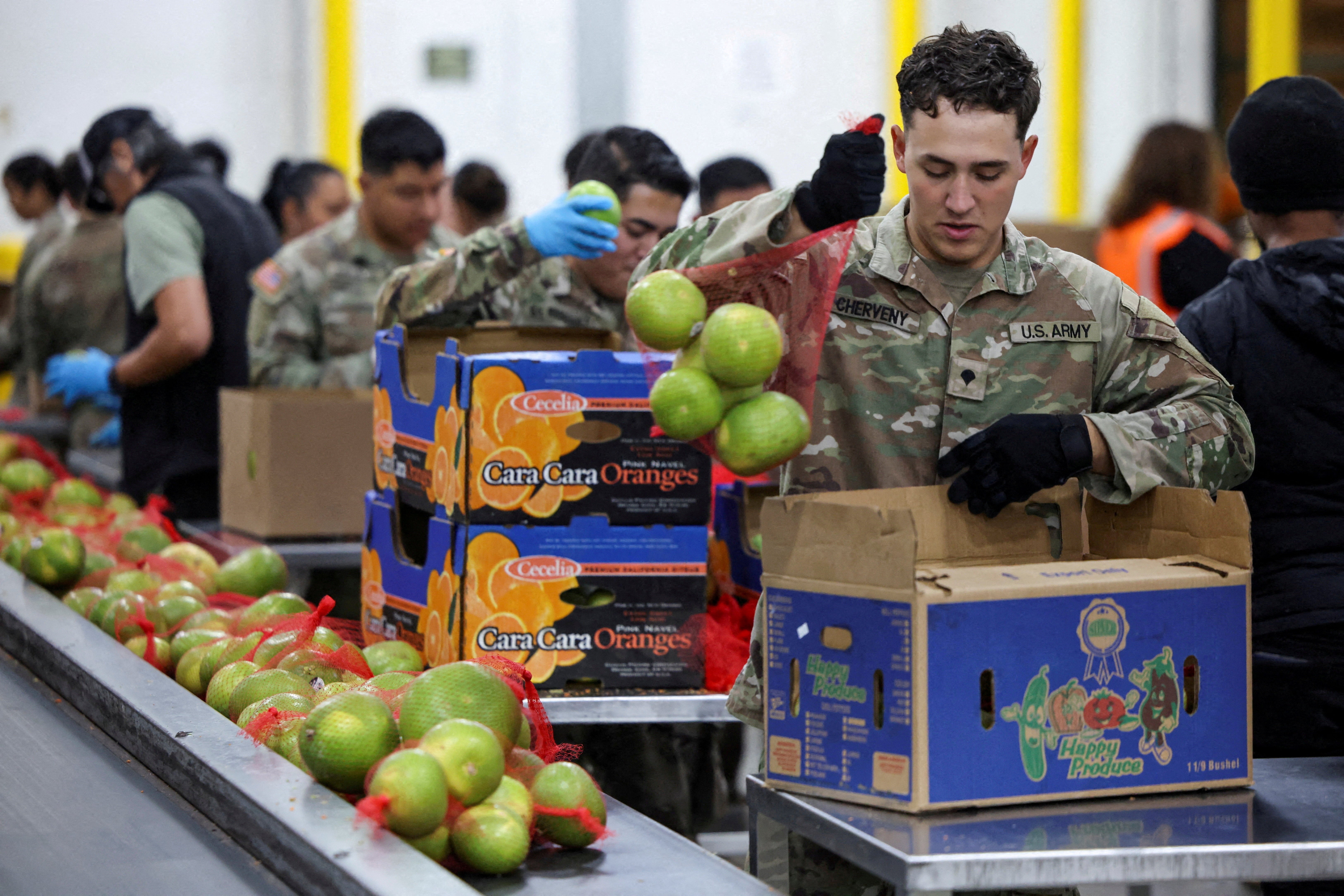 Members of the National Guard pack food at a Los Angeles Regional Food Bank facility. While the shutdown continues multiple federal workers have been forced to work with no pay and aid programs have run out of money