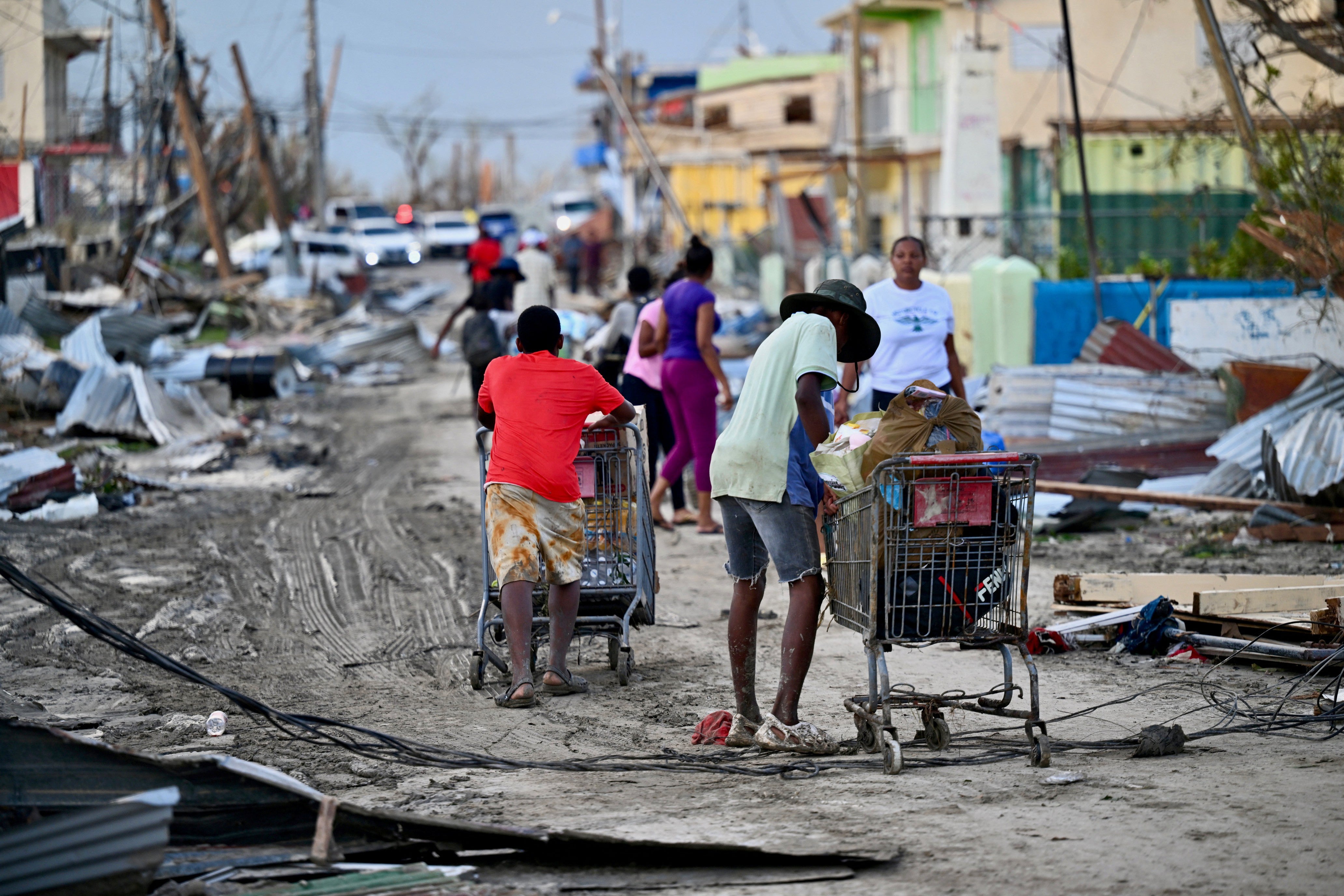 People search for food on the streets of Jamaica’s Black River community Wednesday following the passage of Hurricane Melissa. Scientists say climate-fueled storms like Melissa may necessitate the need for an increased hurricane scale