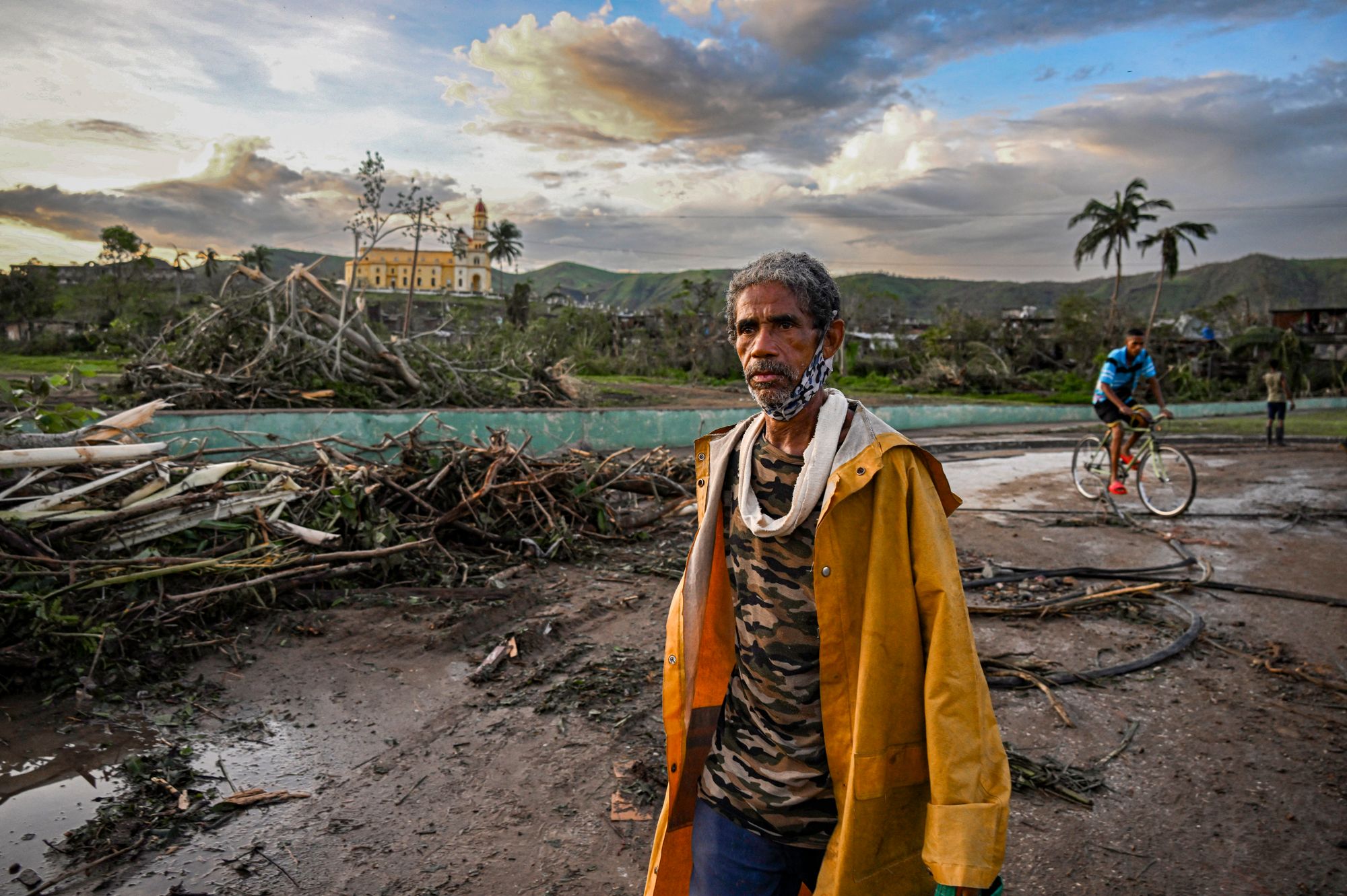 A resident of the town of El Cobre, Cuba, walks past downed trees, power lines and destroyed houses following the passage of Hurricane Melissa on Wednesday. The storm was made four times more likely due to climate change