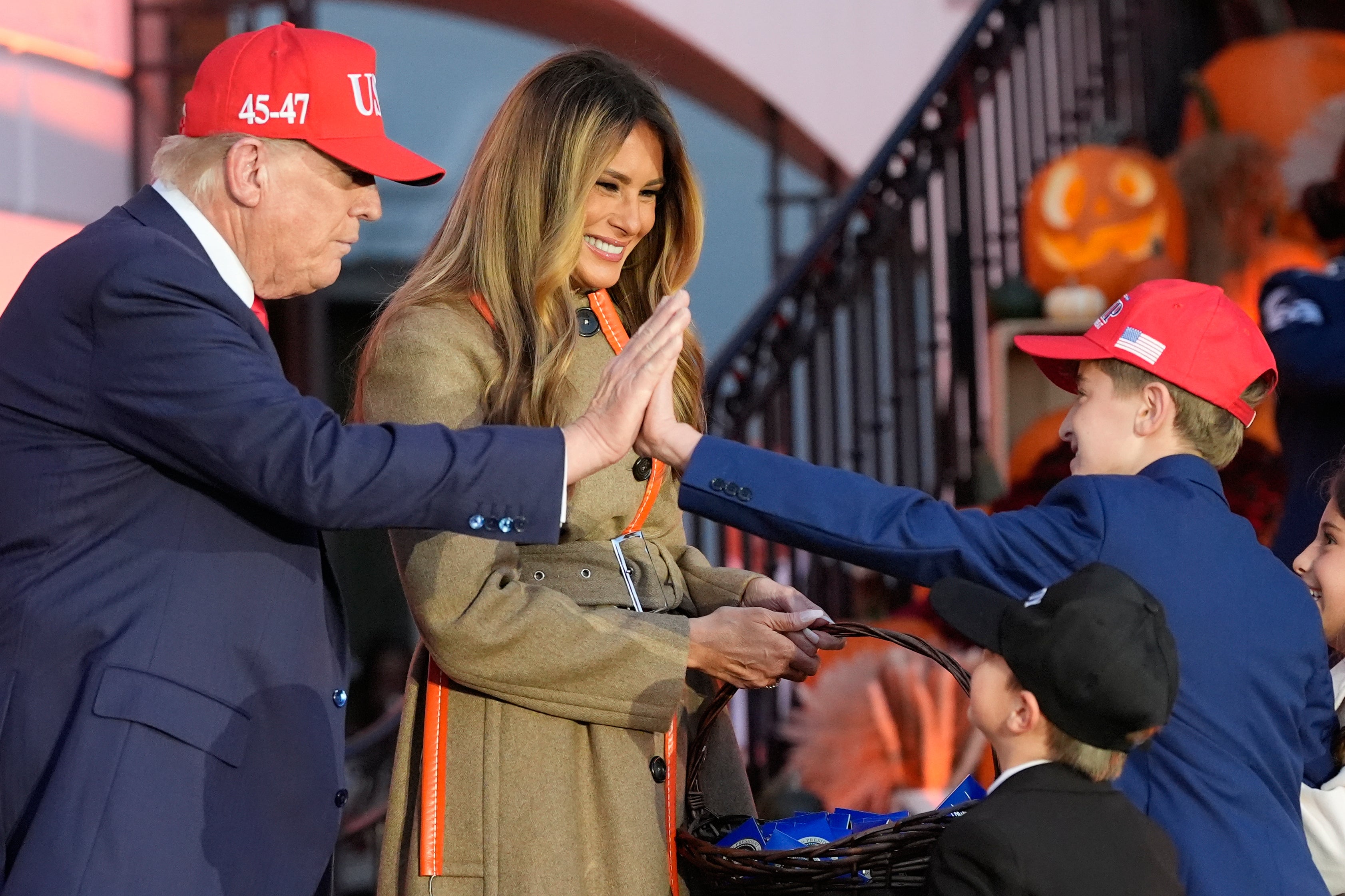 President Donald Trump high-fives a trick-or-treater who appears to be dressed as him at the White House Halloween event