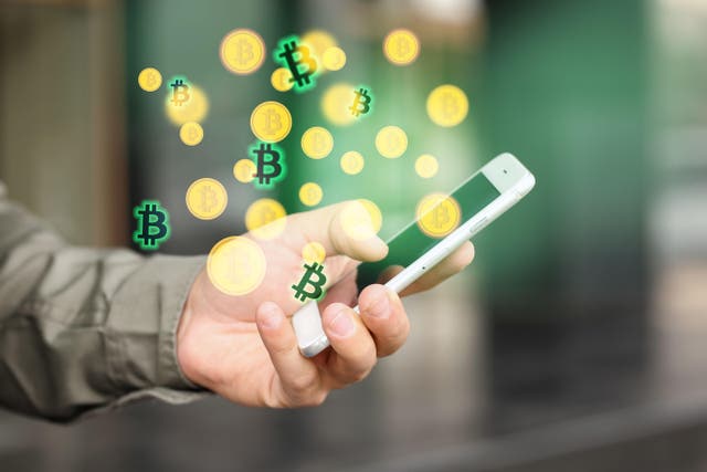<p>Picture of a man holding a phone which is surrounded by Bitcoin logos and illustrations</p>