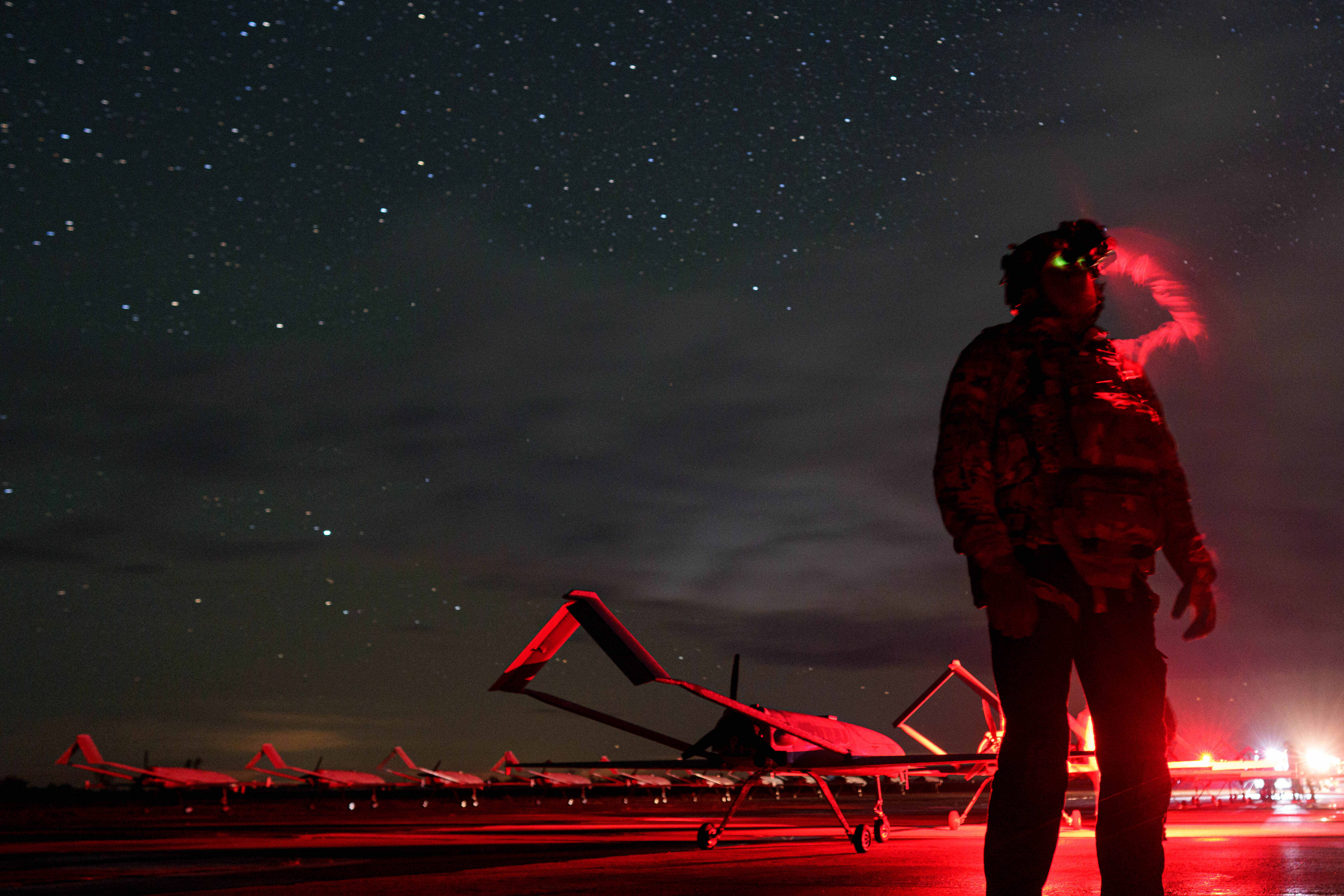 A Ukrainian commander callsign Fidel of the 14th Separate Unmanned Aerial Systems Regiment looks though night vision before takeoff of long-range drones An-196 Liutyi towards Russia