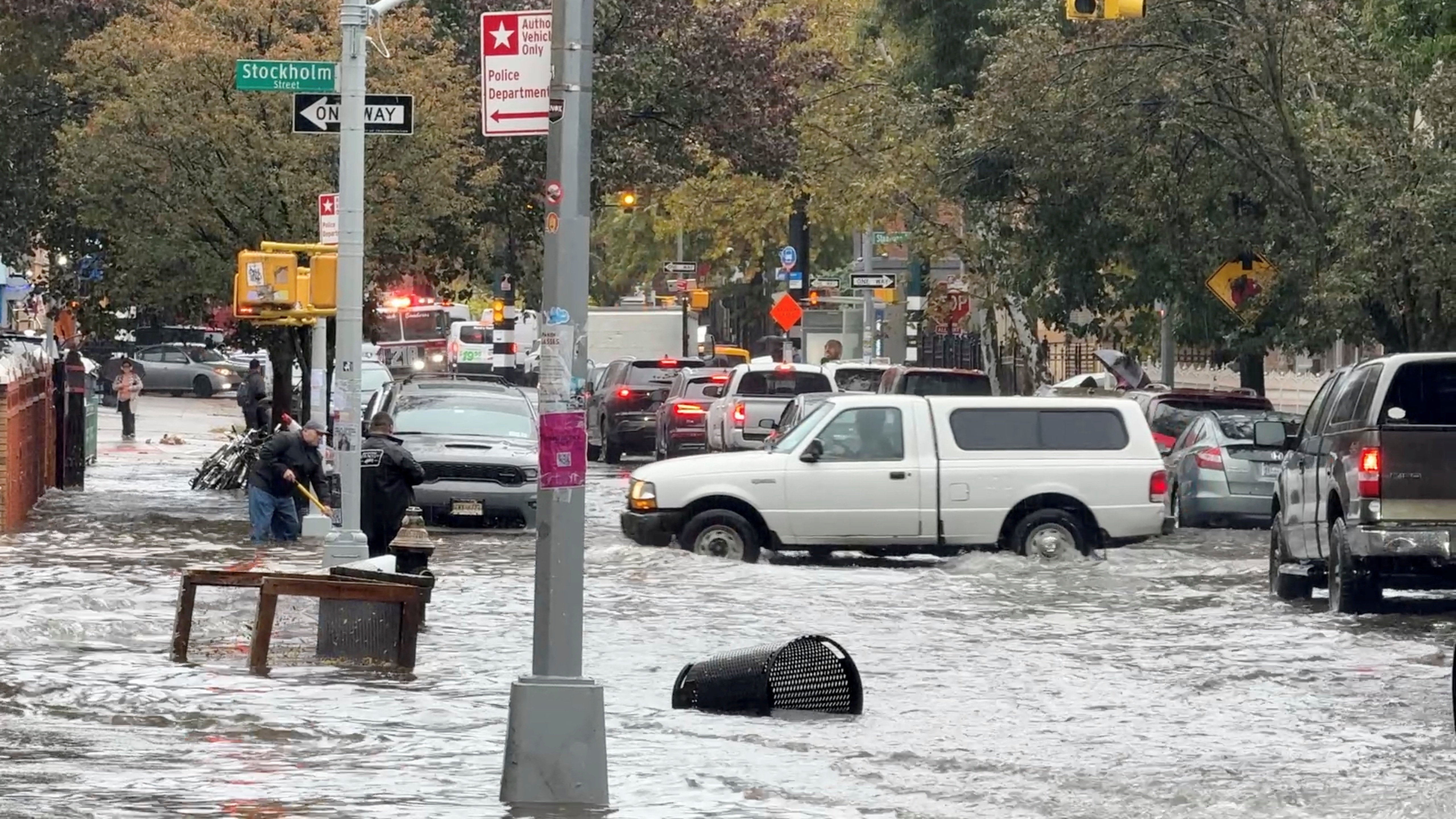 Vehicles move through flooded streets in New York City on Thursday. The rainfall broke three daily records in the region