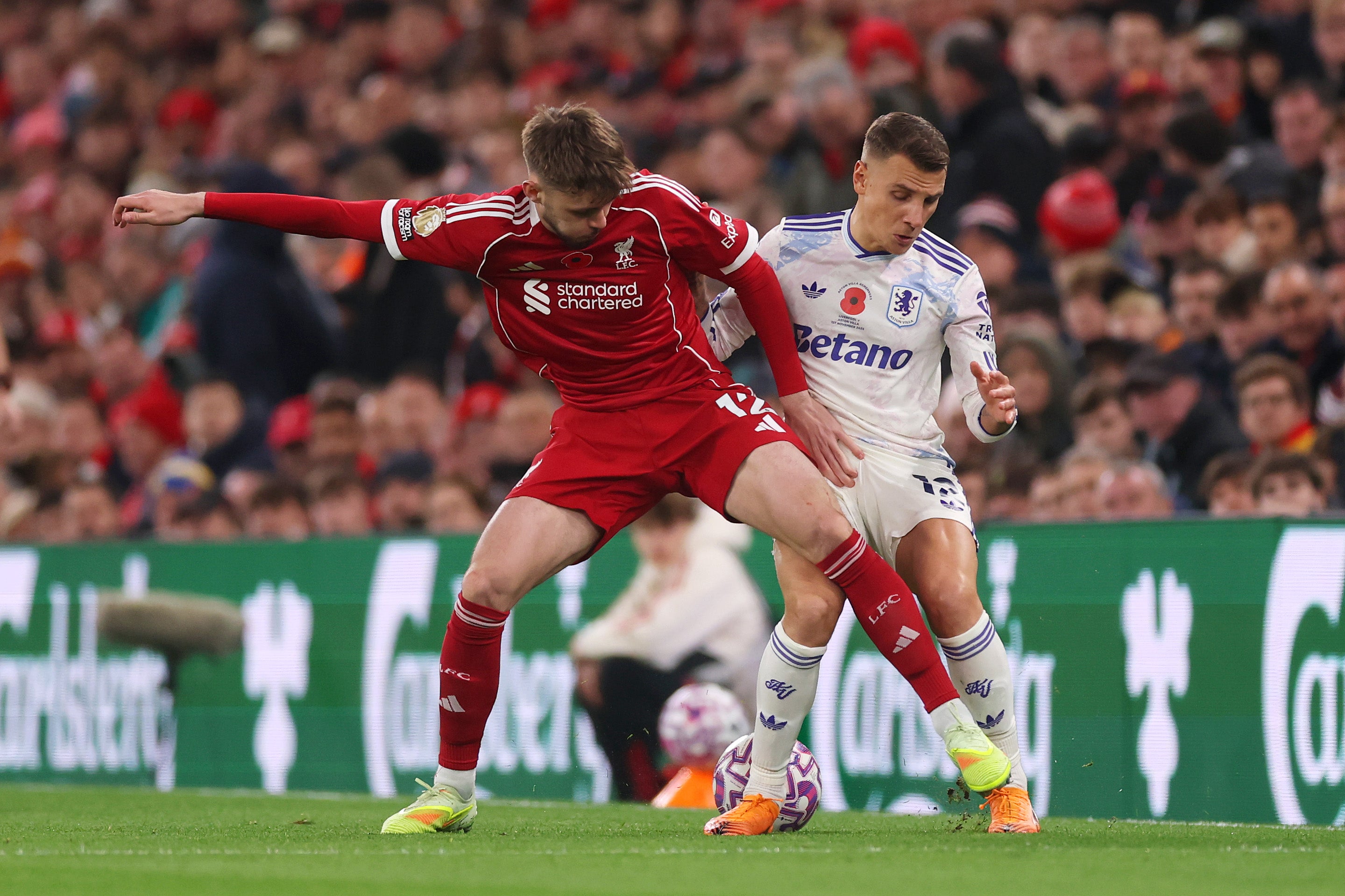 Conor Bradley, vlevo, bojuje s Lucasem Dignem o míč