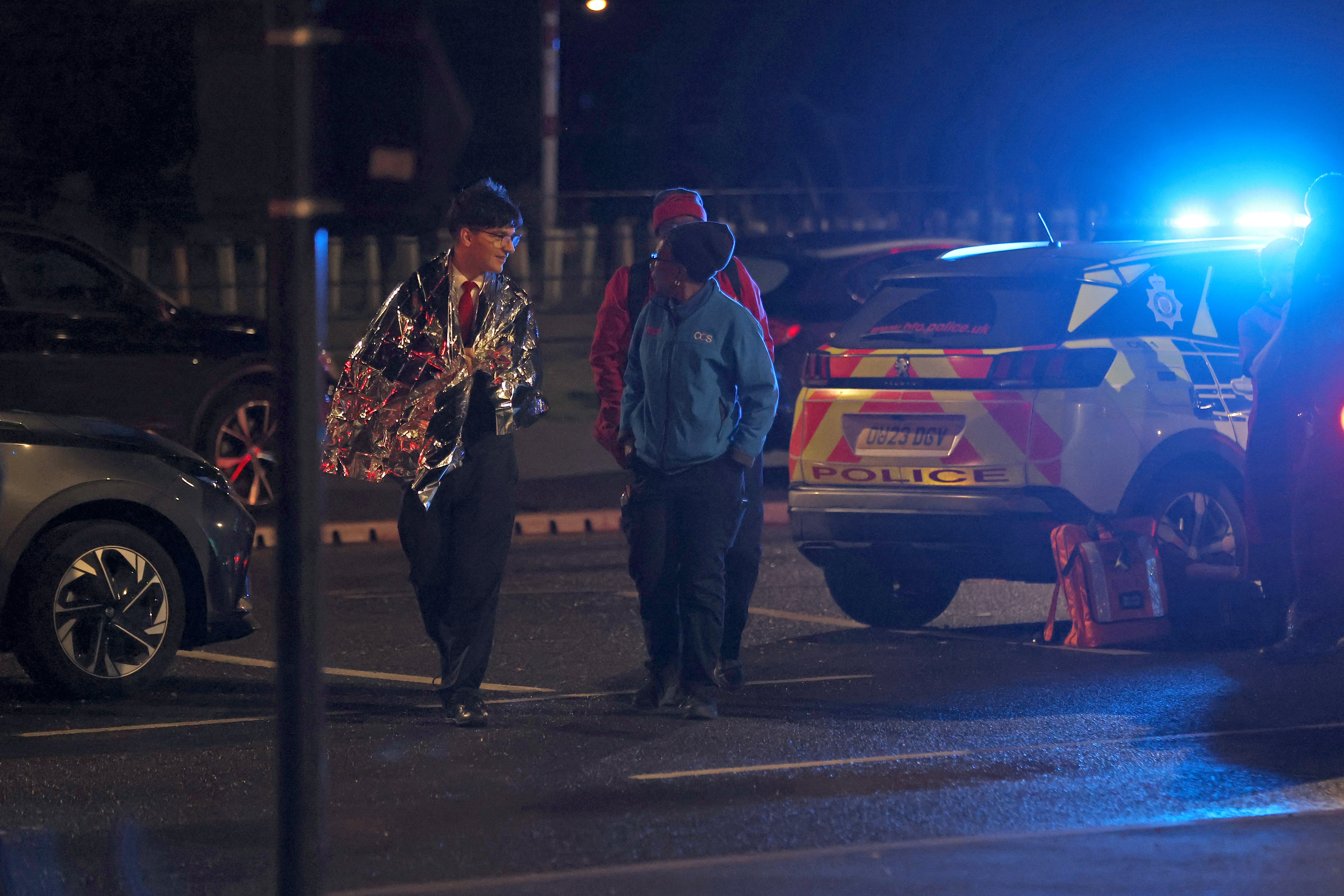 A man wearing an emergency foil blanket near the scene at Huntingdon train station