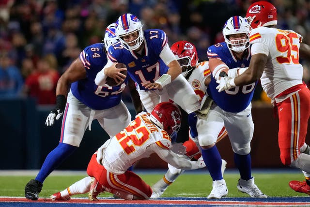 Buffalo Bills quarterback Josh Allen leaps over Kansas City Chiefs cornerback Trent McDuffie (Sue Ogrocki/AP)