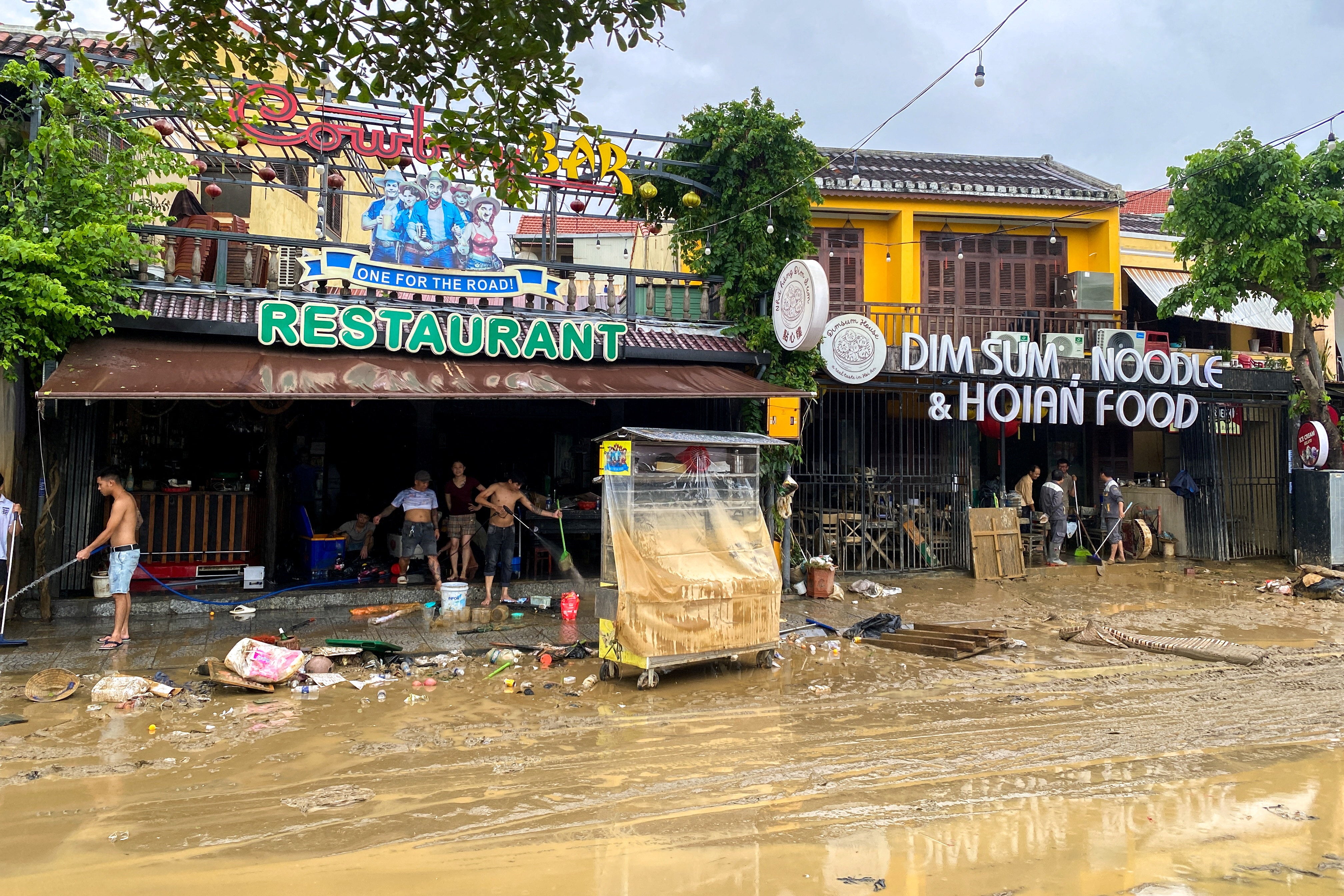 People clean a restaurant following floods in central Vietnam that have killed several people, in Hoi An.