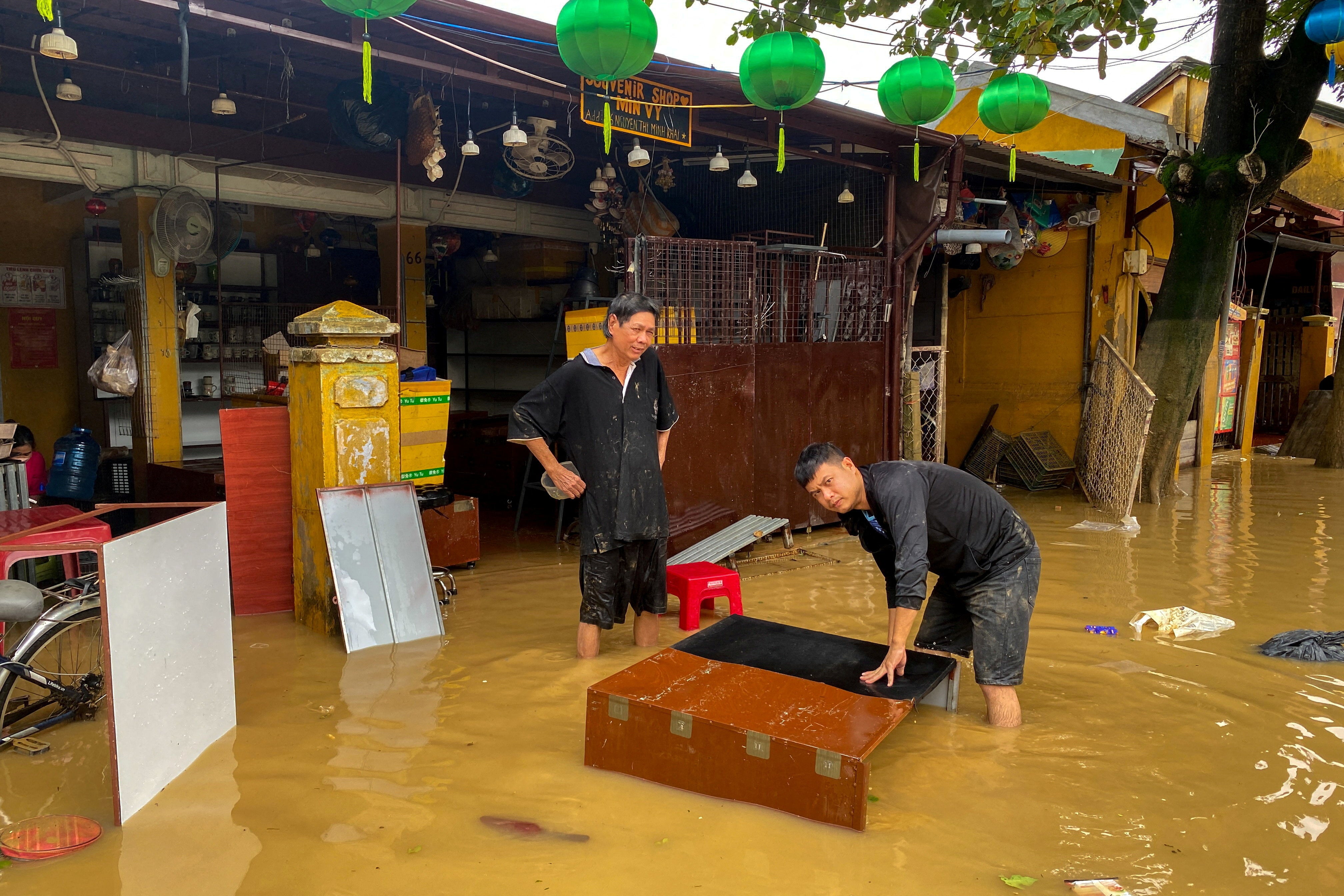 People clean their furniture in a flooded area in Hoi An, following deadly floods in central Vietnam.