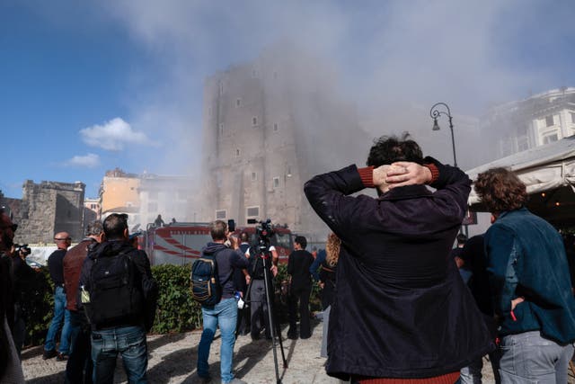 <p>Onlookers watch as dust rises following the collapse of parts of the Torre dei Conti</p>
