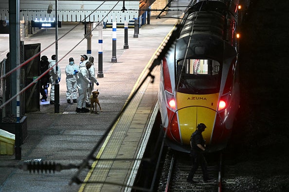 Police officers working on Huntingdon station platform after the knife attack