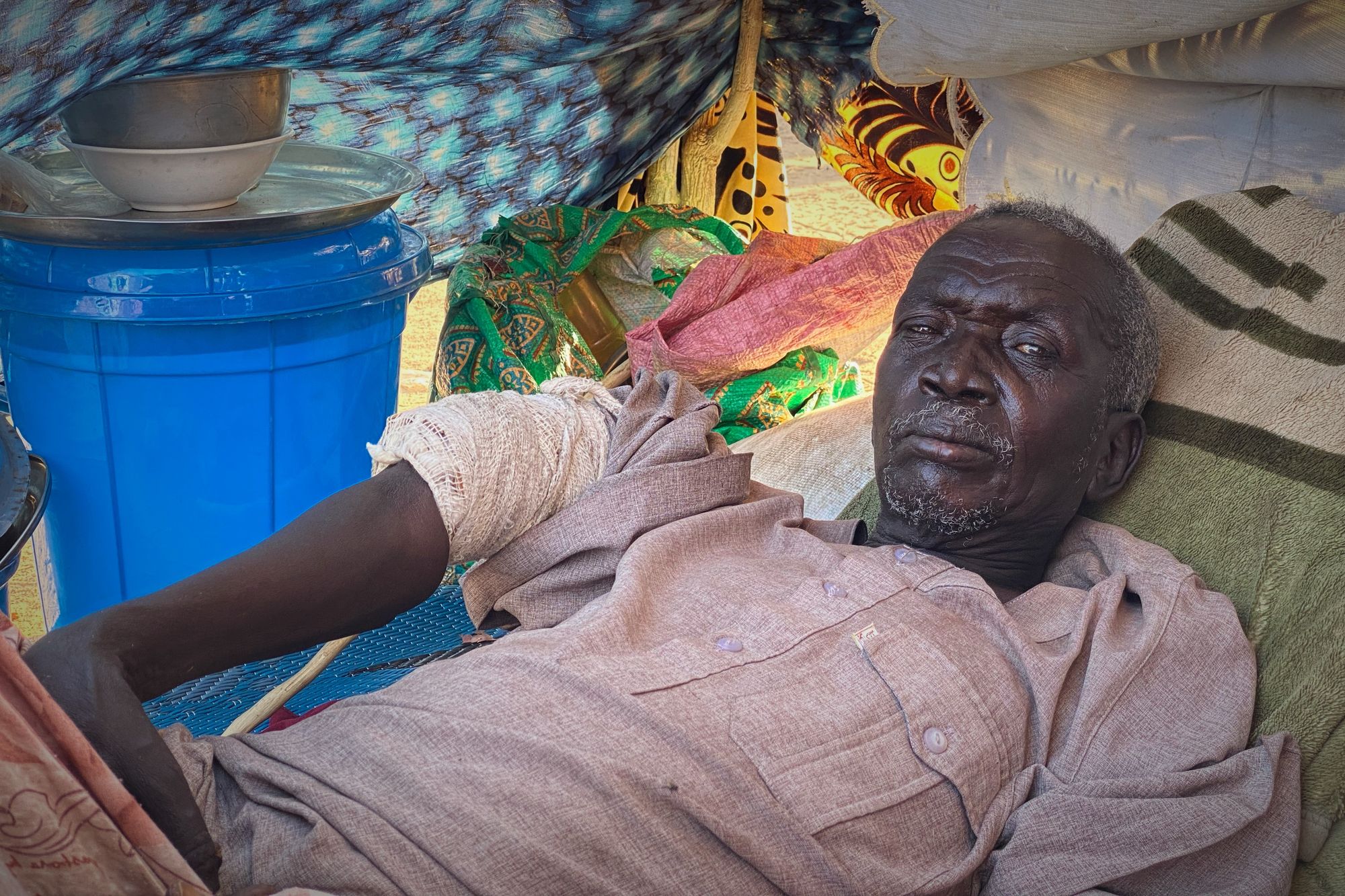 An injured Sudanese man who fled el-Fasher city, after Sudan's paramilitary forces killed hundreds of people in the western Darfur region, rsits in a tent at a camp in Tawila, Sudan.
