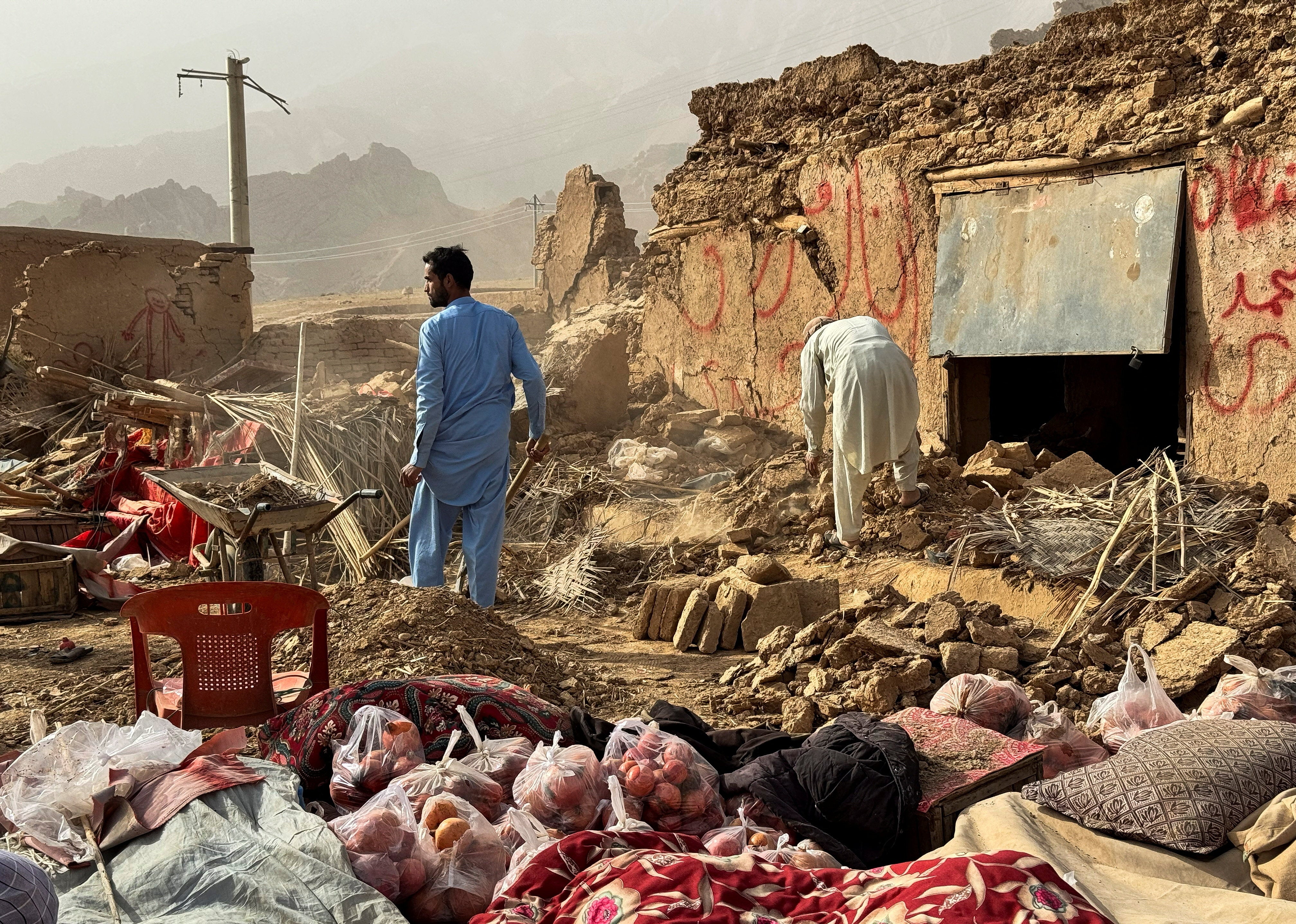 People search the debris of damaged buildings in the aftermath of an earthquake in Samangan province, Afghanistan.