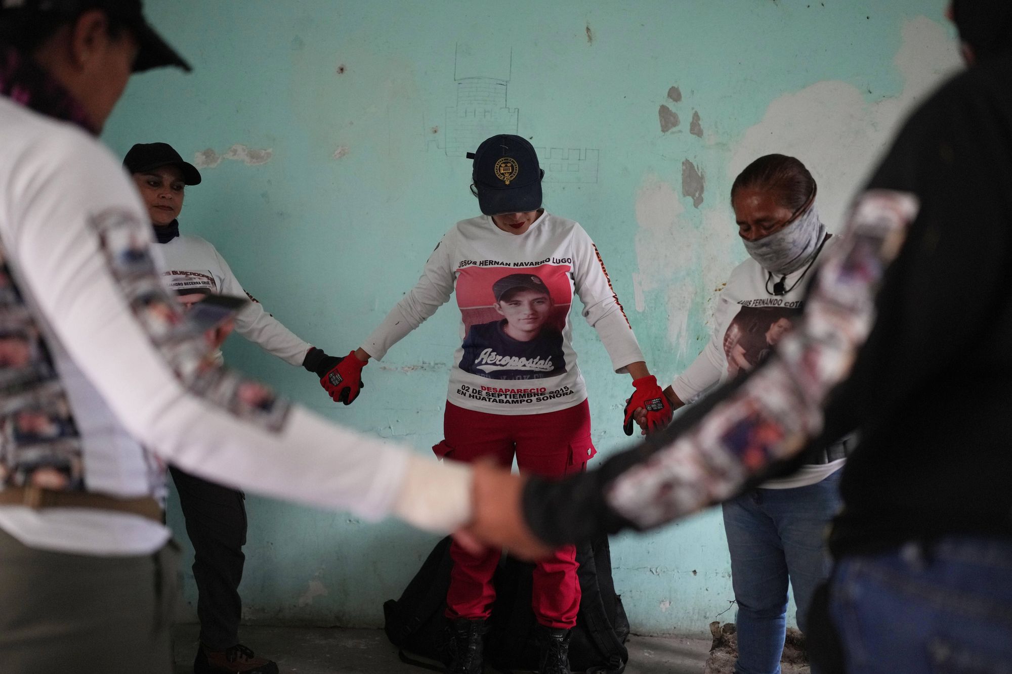 <p>Relatives of missing people, part of a group called the Guerreros Buscadores, pray before inspecting an area where they suspect bodies may be buried, in the Valle de los Olivos neighborhood of Guadalajara, Mexico, Oct. 14, 2025</p>