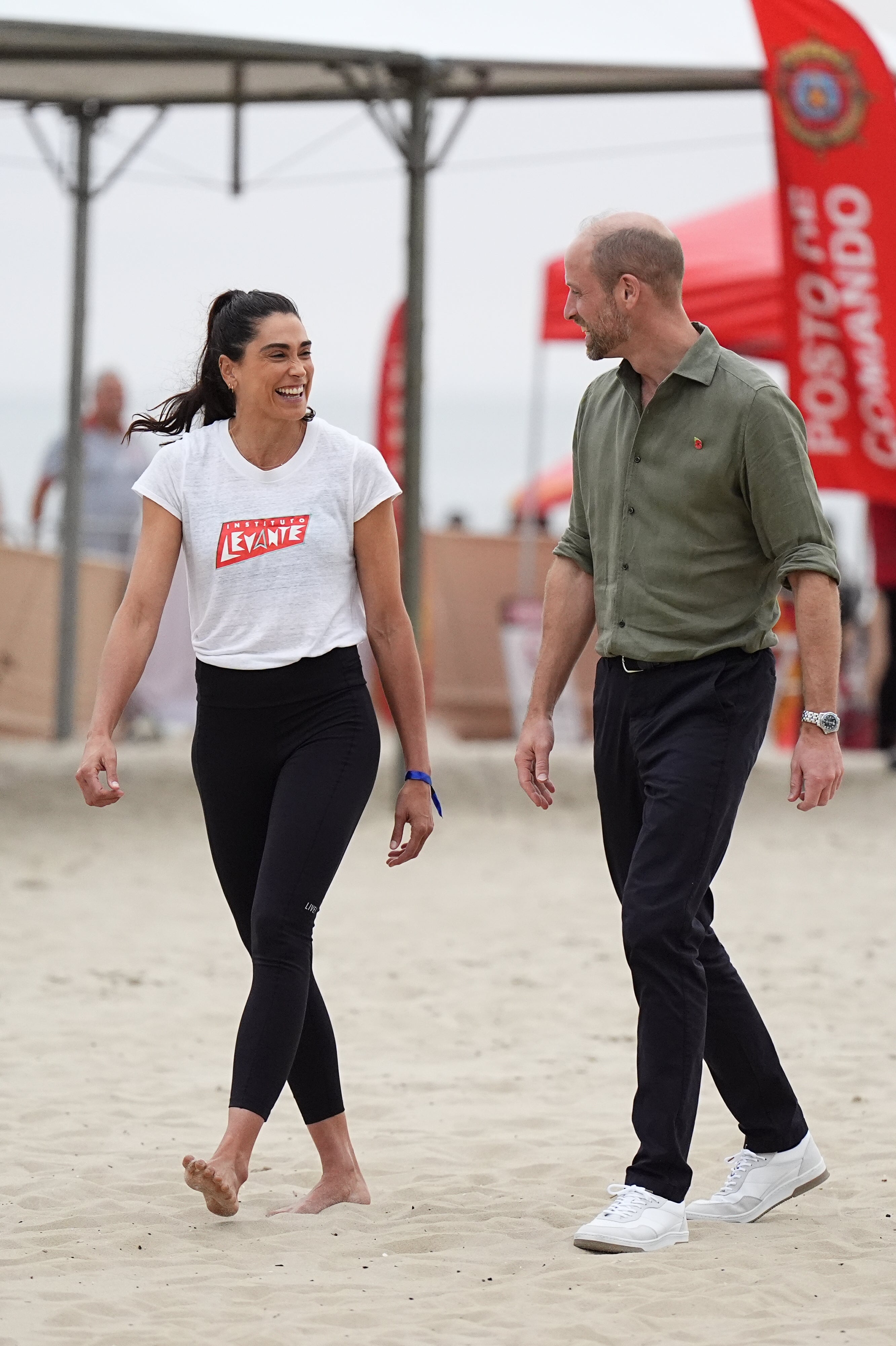 The Prince of Wales walks with Brazilian beach volleyball player Carolina Solberg Salgado (Aaron Chown/PA)
