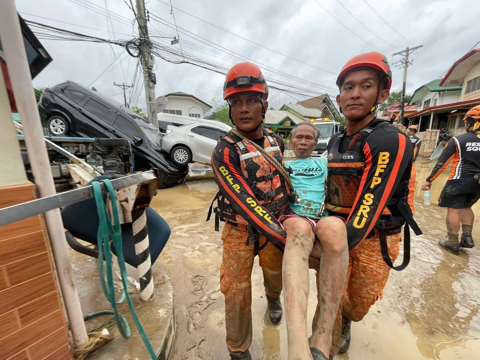 Rescue workers carry a man after flooding caused by the typhoon