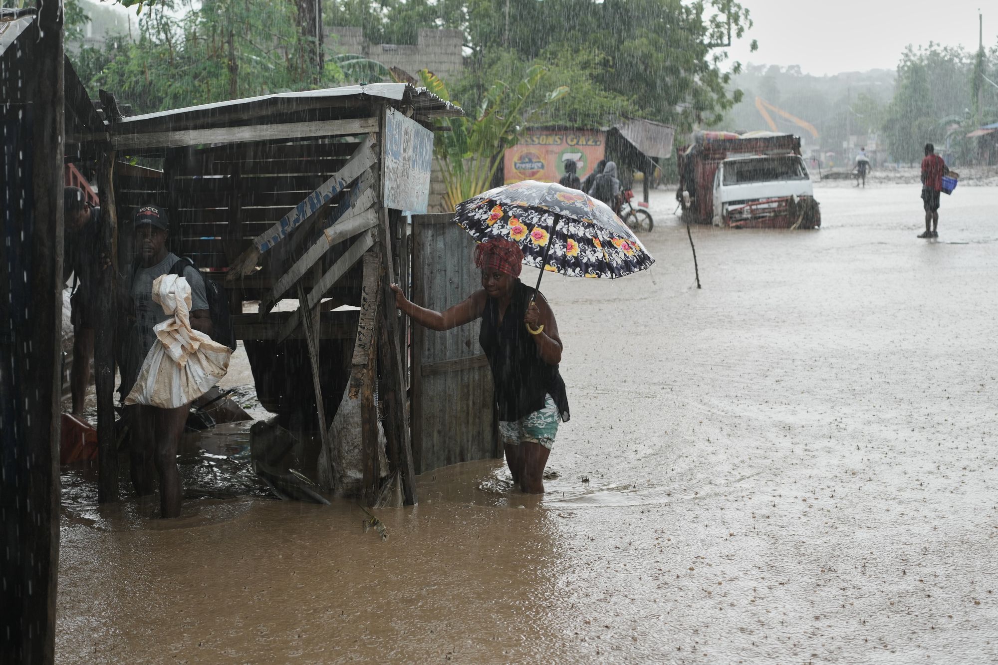 Residents wade through a flooded street in the aftermath of Hurricane Melissa in Petit-Goave, Haiti, Thursday, Oct. 30, 2025