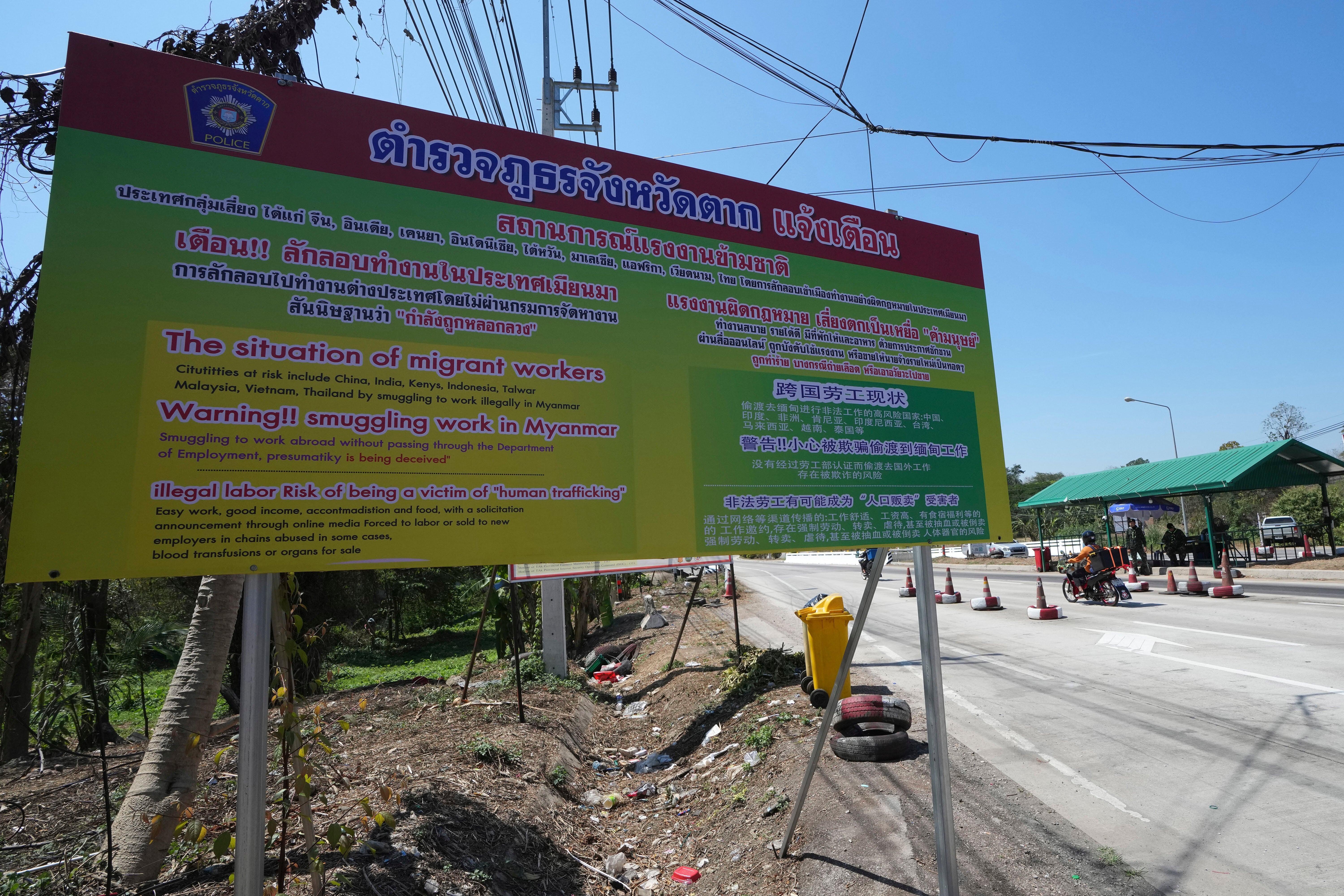 A sign warns of the danger of being trafficked and forced to work in locked scam compounds in Myanmar